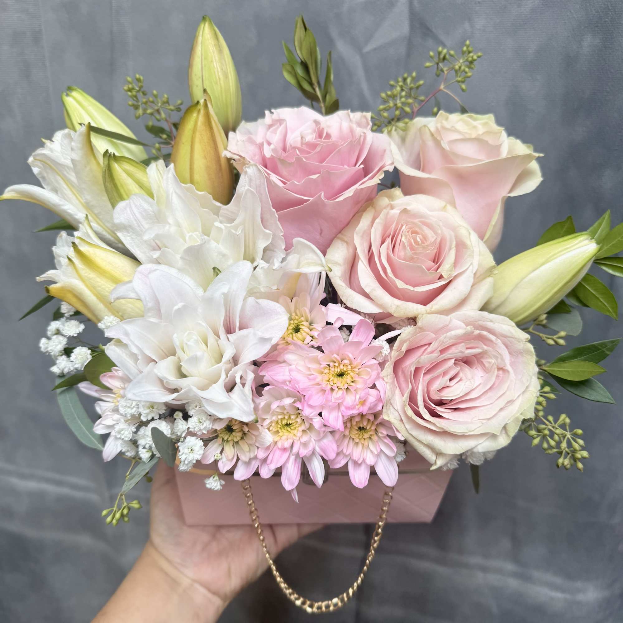 Pink and white roses with lilies in a pink gift box