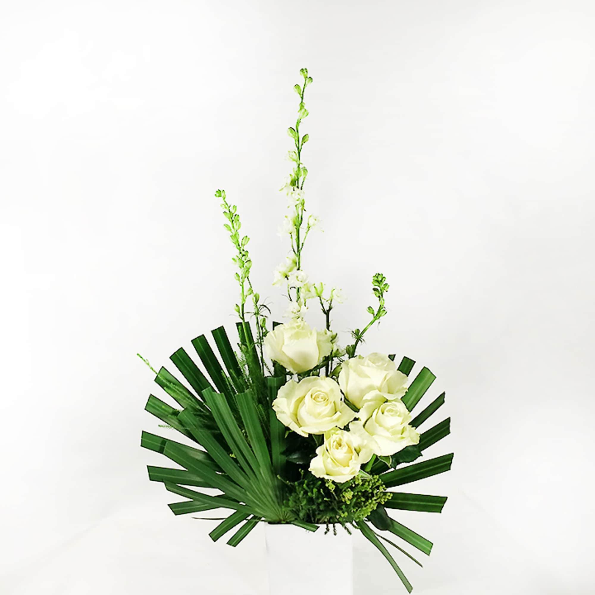 White roses with tall white spikes in a white vase
