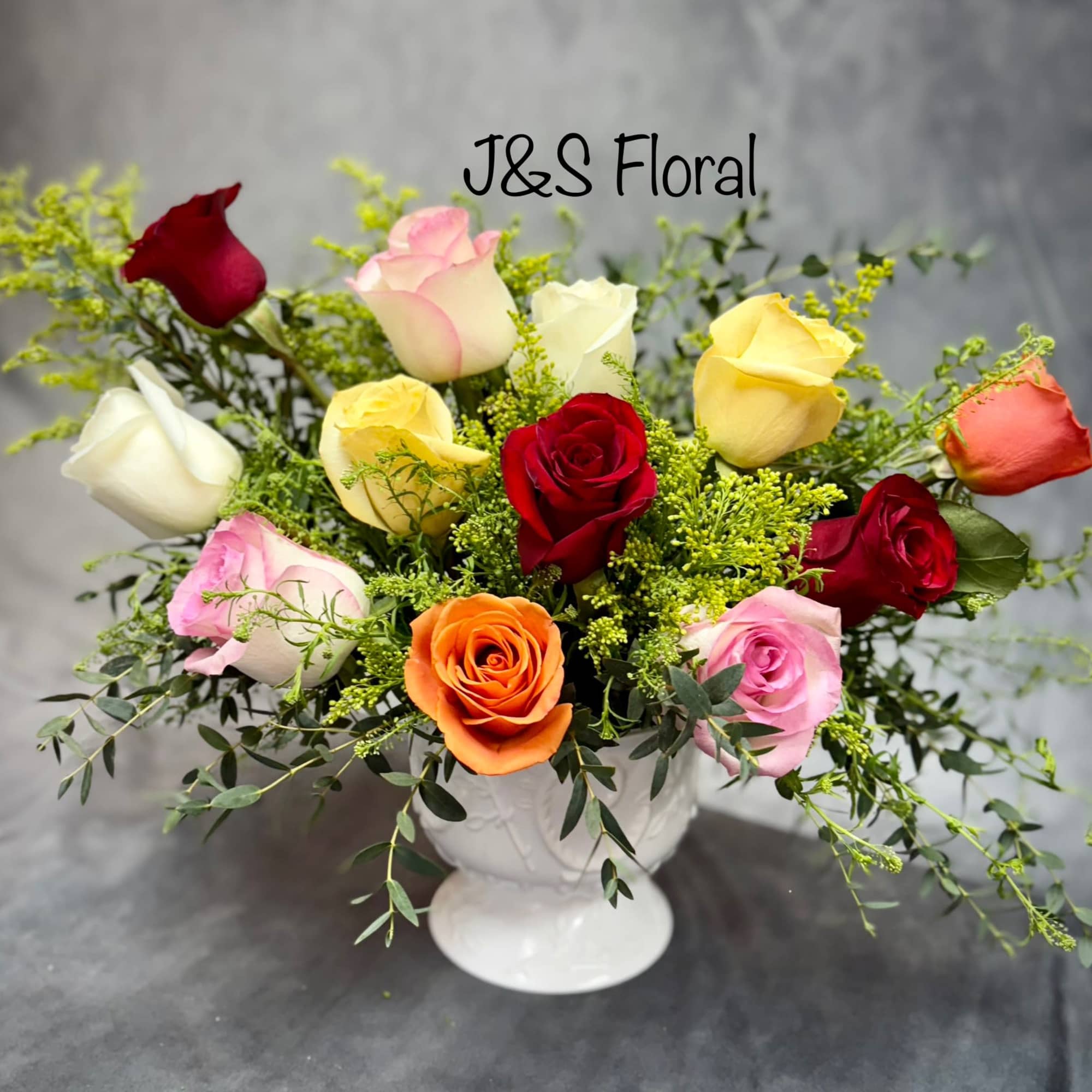 Mixed roses in a white pedestal vase