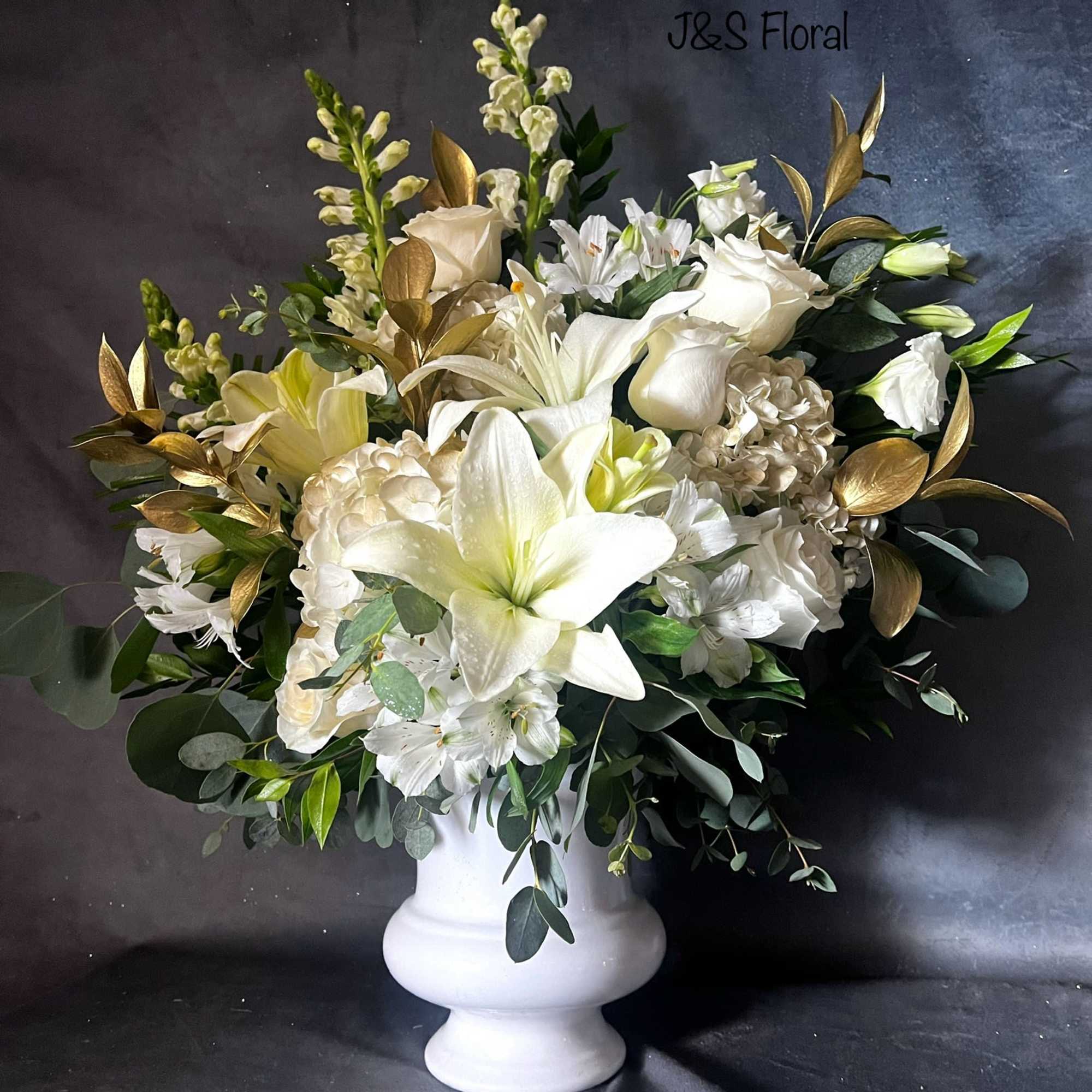 White floral arrangement in a white pedestal vase with gold foliage accents, photo 2 of 2