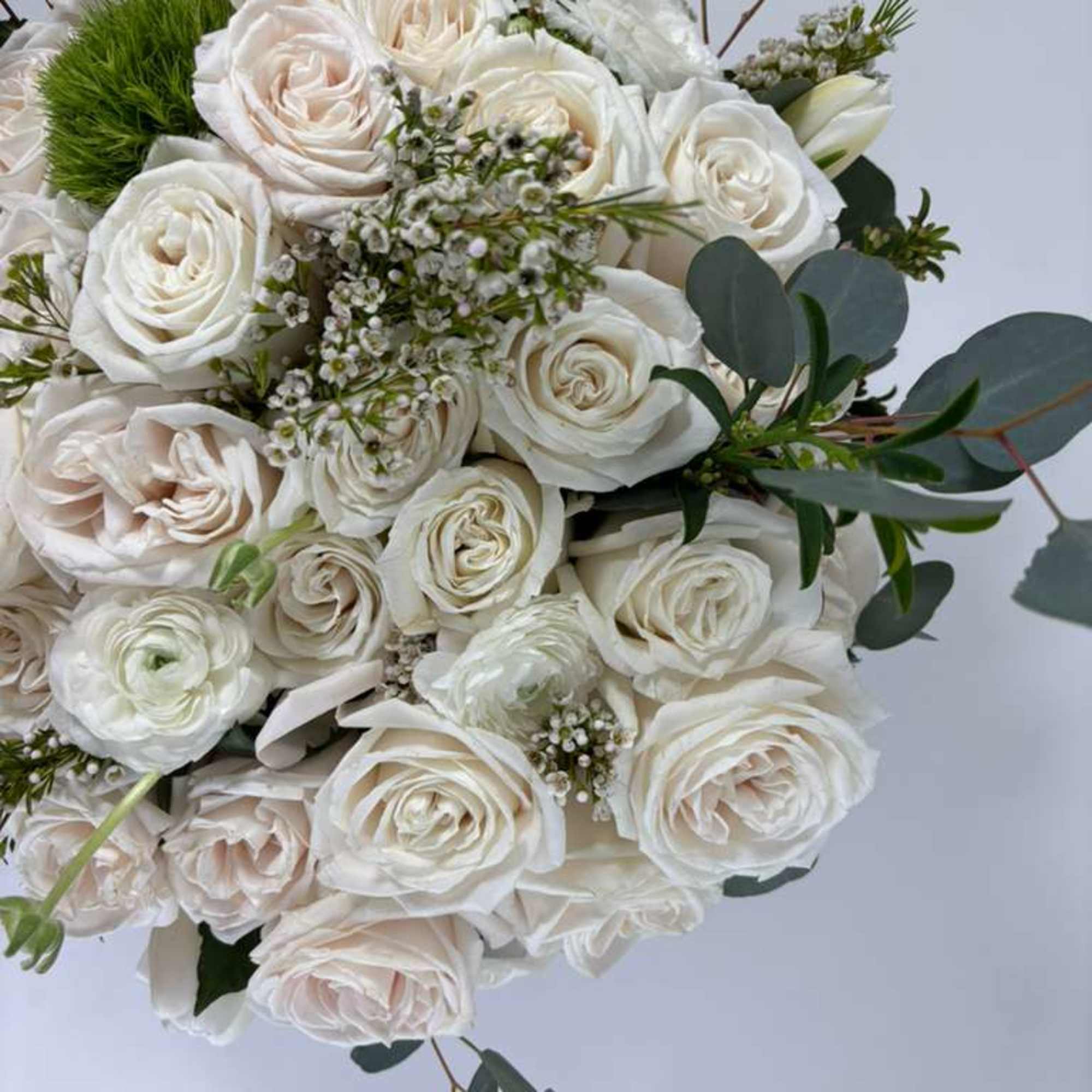 Bouquet of white roses with eucalyptus and small filler flowers
