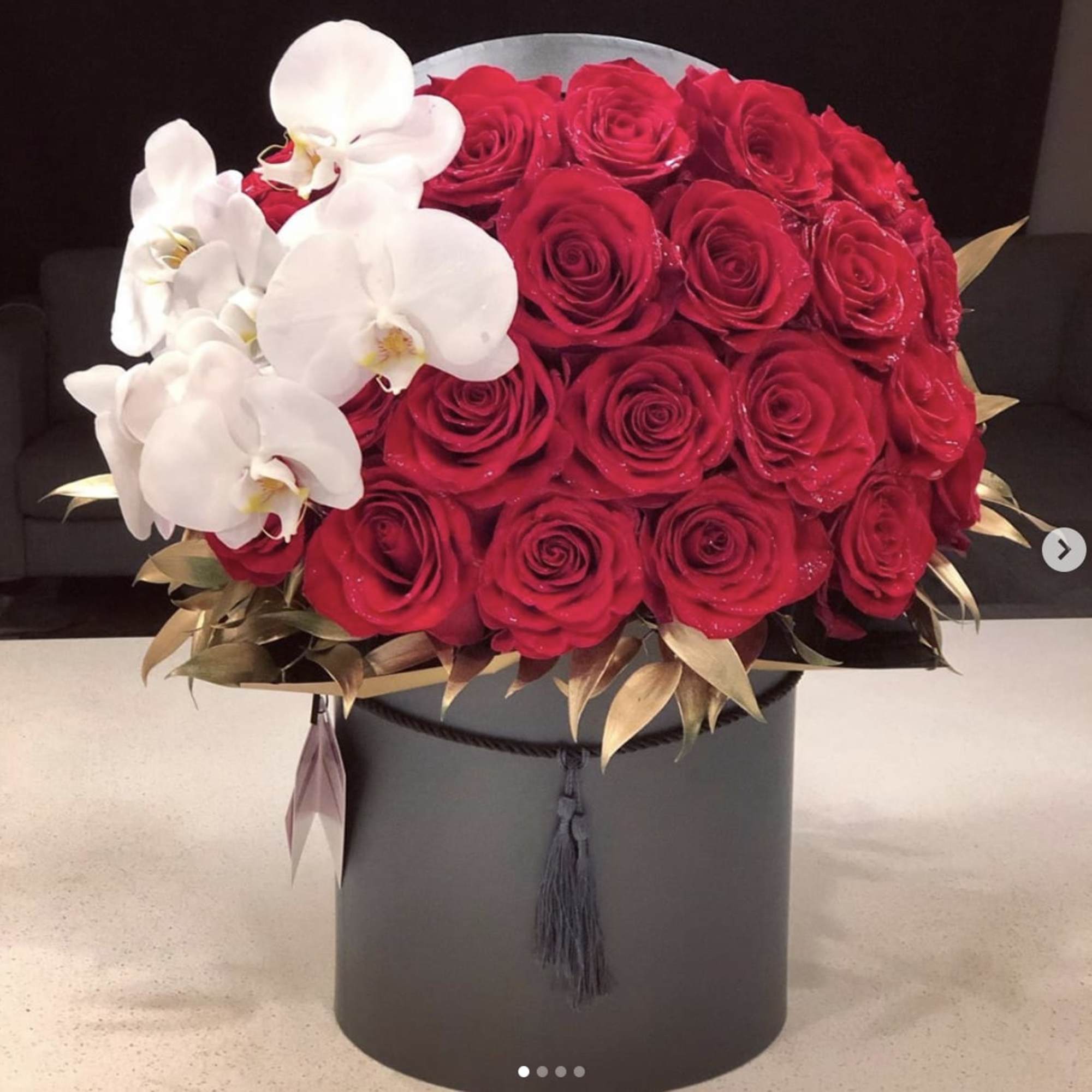 Red rose bouquet with white orchids in a black hat box