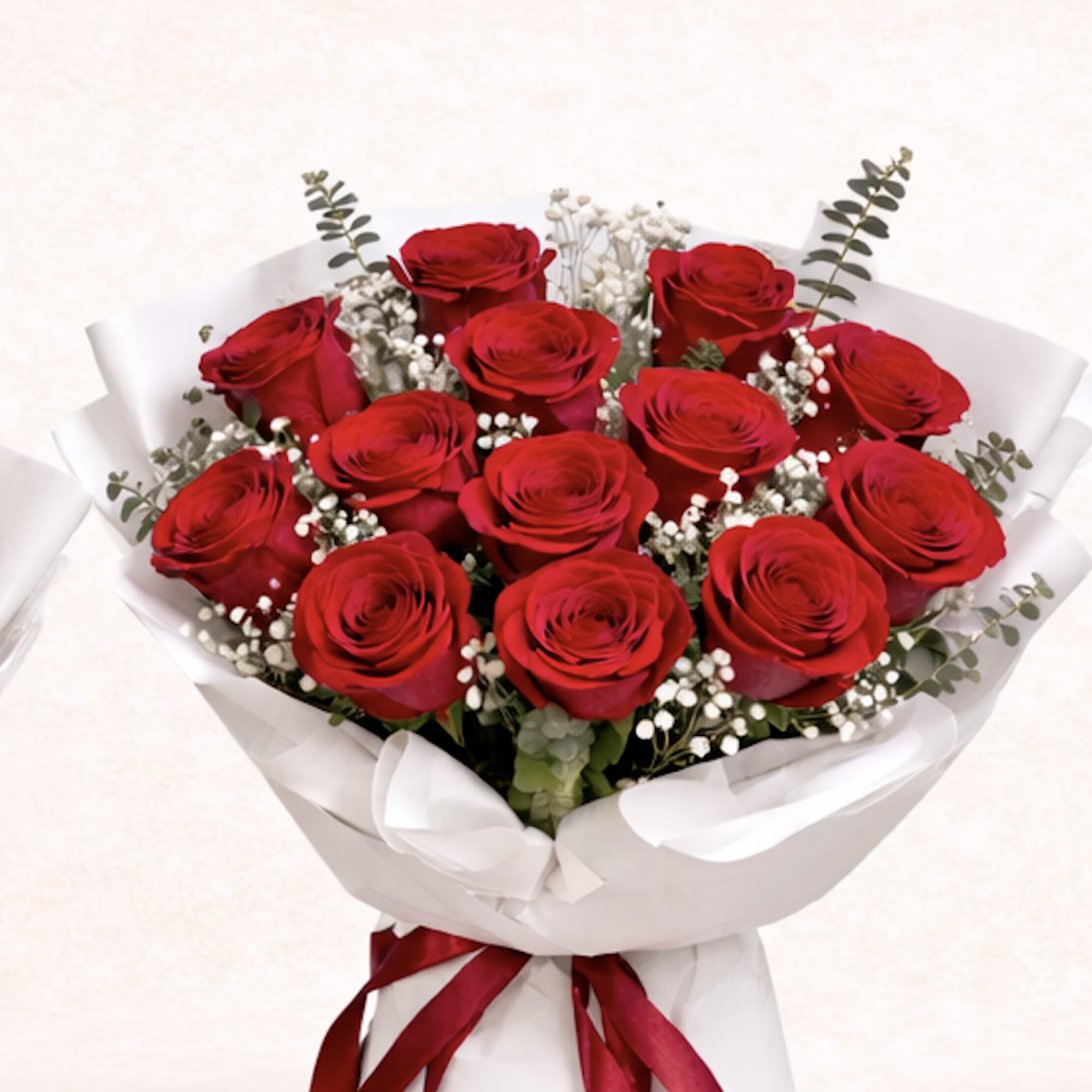Bouquet of red roses with white baby's breath wrapped in white paper