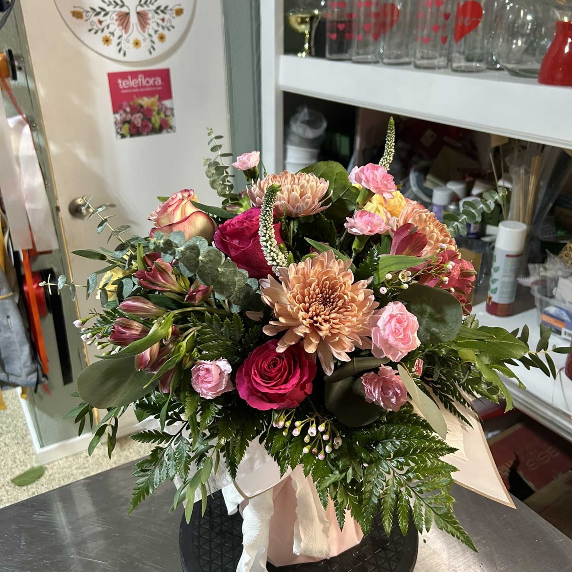 Mixed pink and peach floral arrangement in a vase with greenery