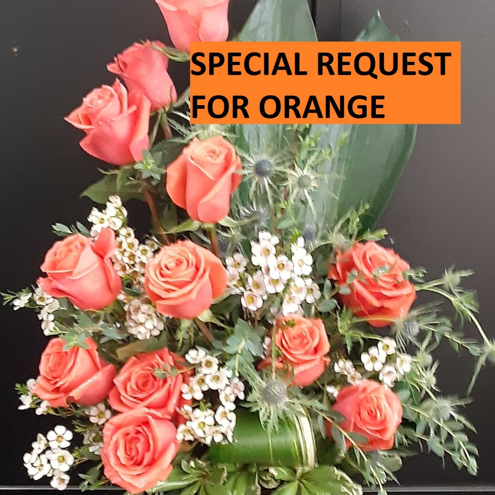 Coral rose arrangement with white filler flowers and greenery