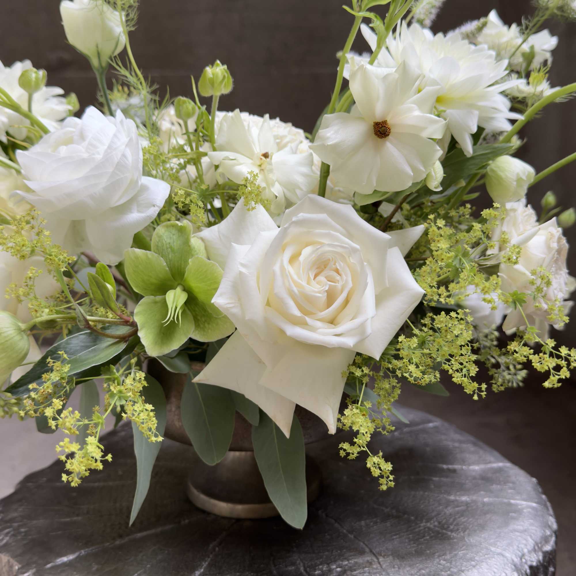 White roses and mixed white blooms arranged in a low vase