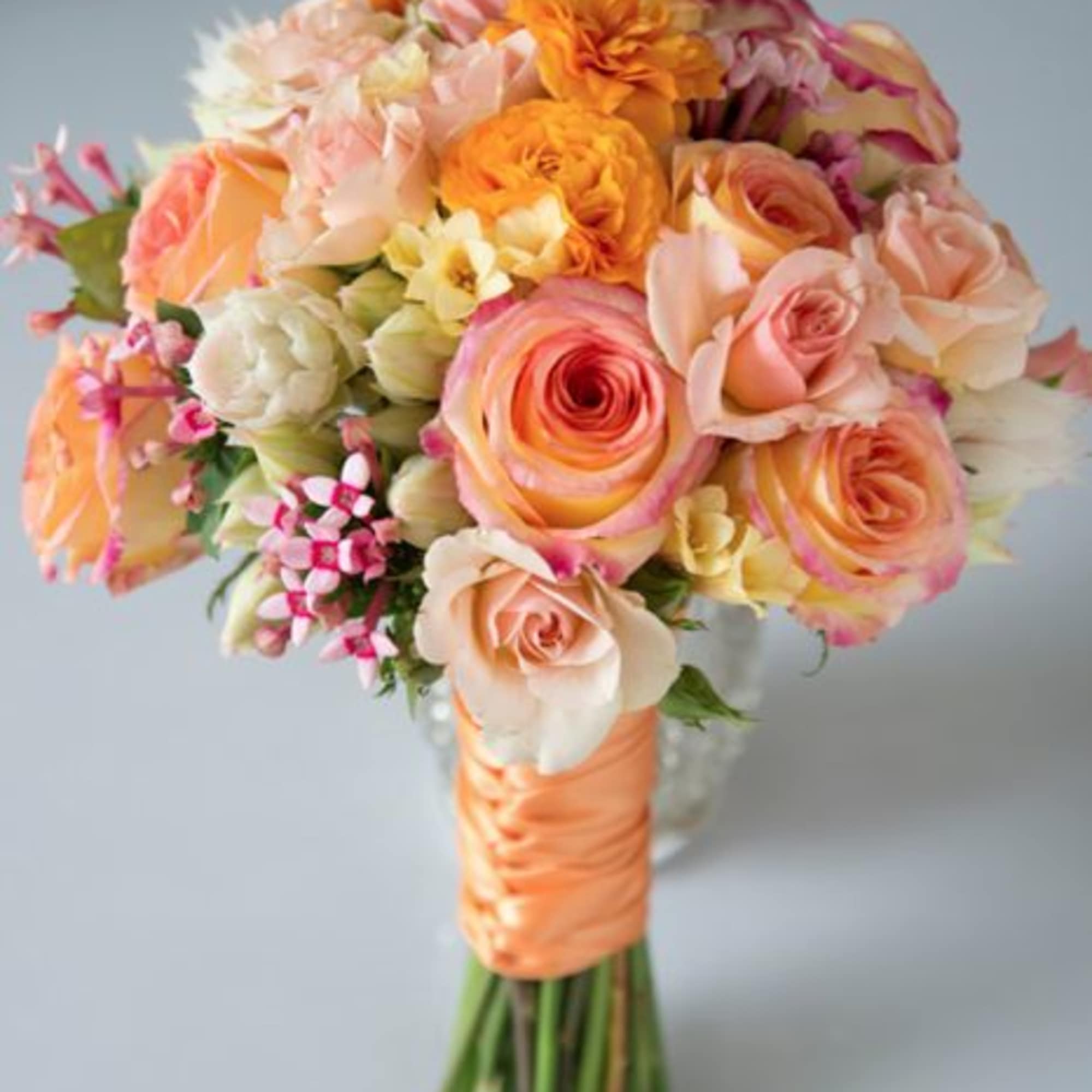 Hand-tied bouquet of peach, pink, and orange roses