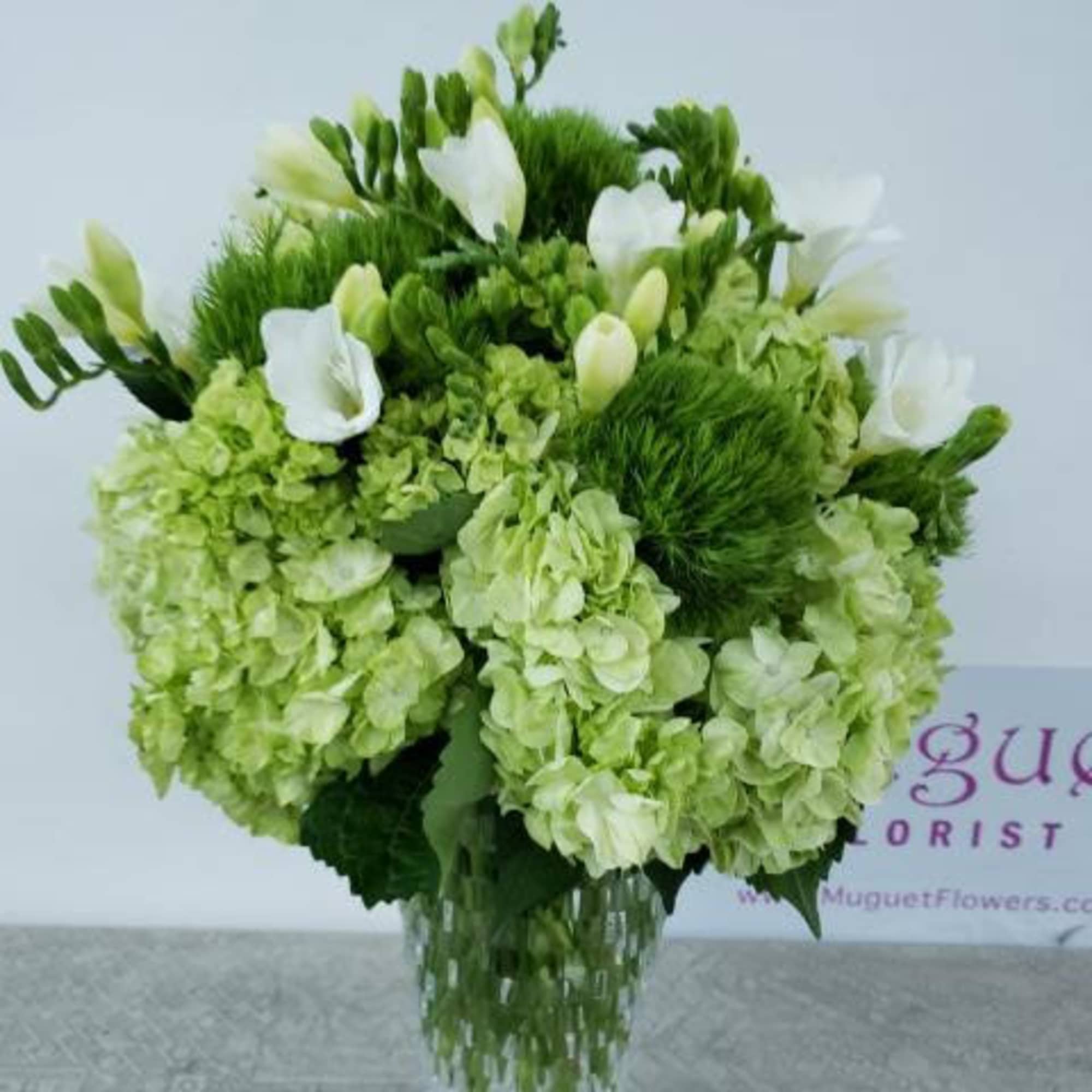 Green and white floral arrangement in a clear glass vase, photo 4 of 4