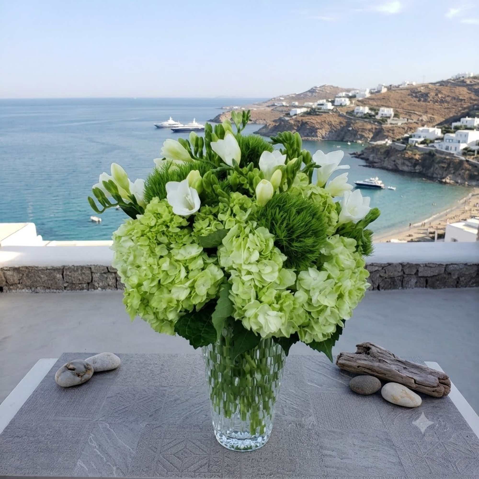 Green and white floral arrangement in a clear glass vase