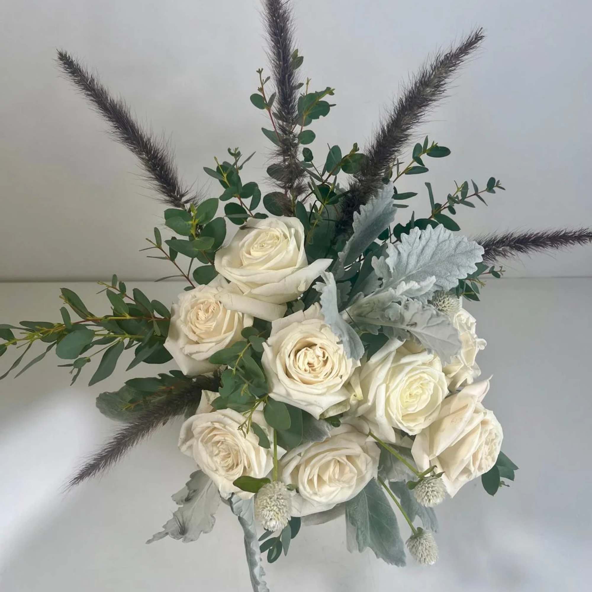 White rose bouquet with eucalyptus and dark feathery accents