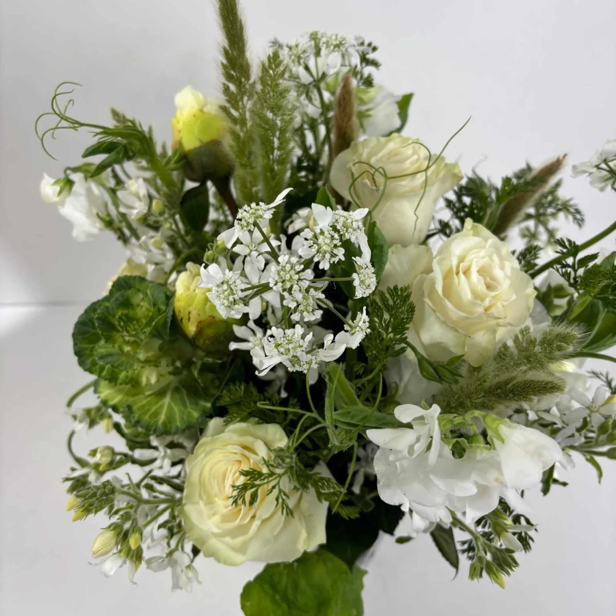 White and pale yellow rose bouquet with mixed greenery and white filler flowers