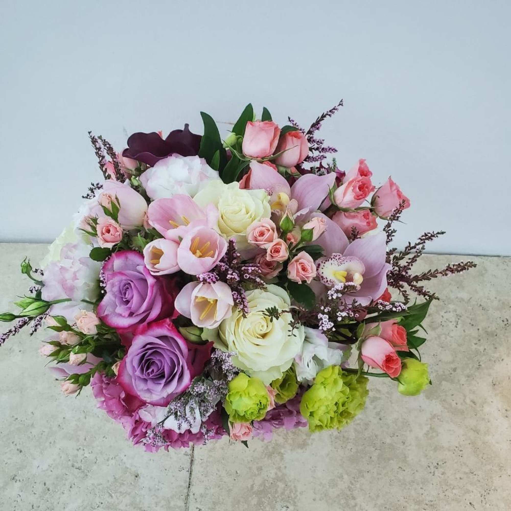 Bouquet of pink, purple, and white flowers with green accents