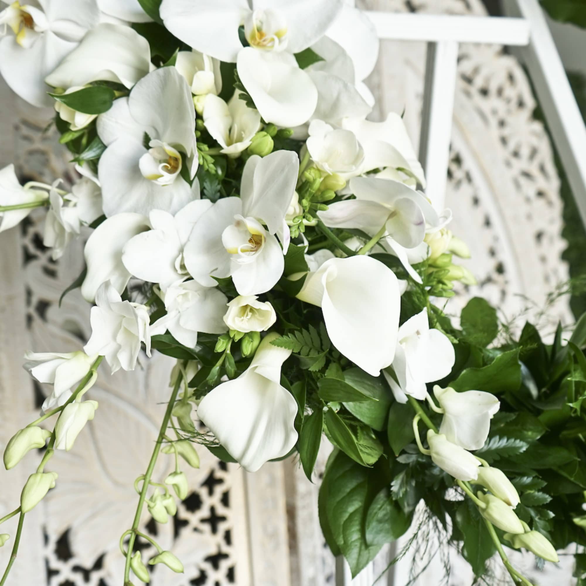 White orchid and calla lily bouquet with green foliage
