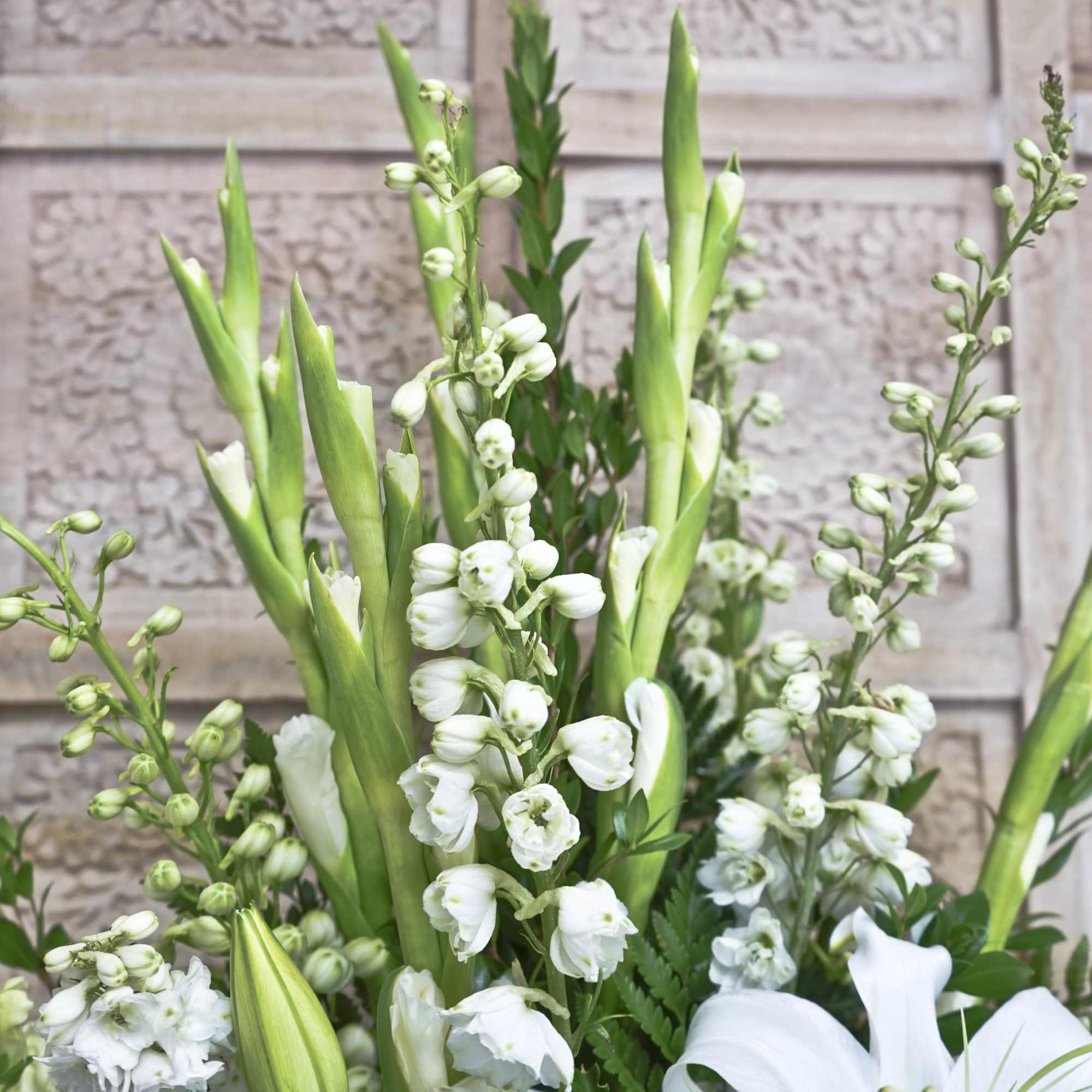 White flowers and green buds arranged with tall calla lilies