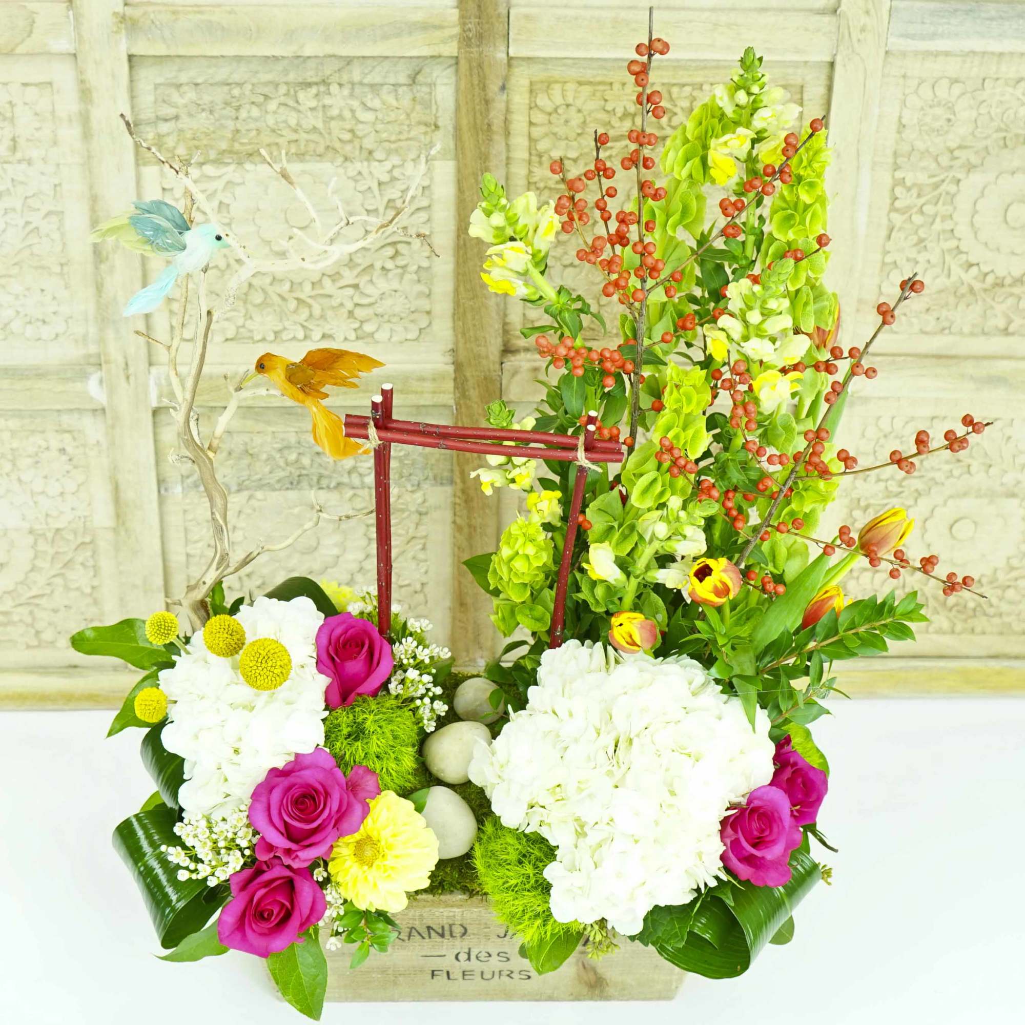 Colorful floral arrangement with roses, hydrangeas, and decorative bird accents