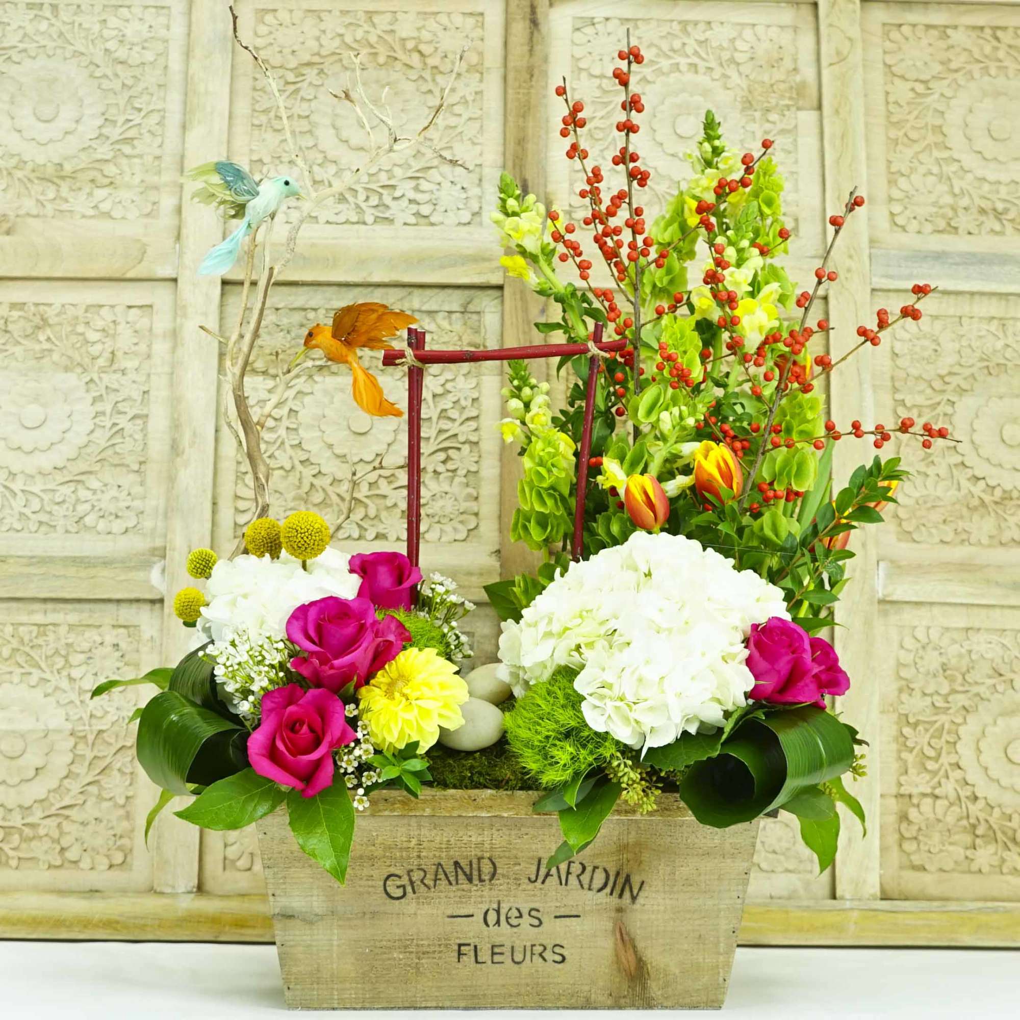 Colorful floral arrangement in a wooden box with pink roses and white hydrangeas