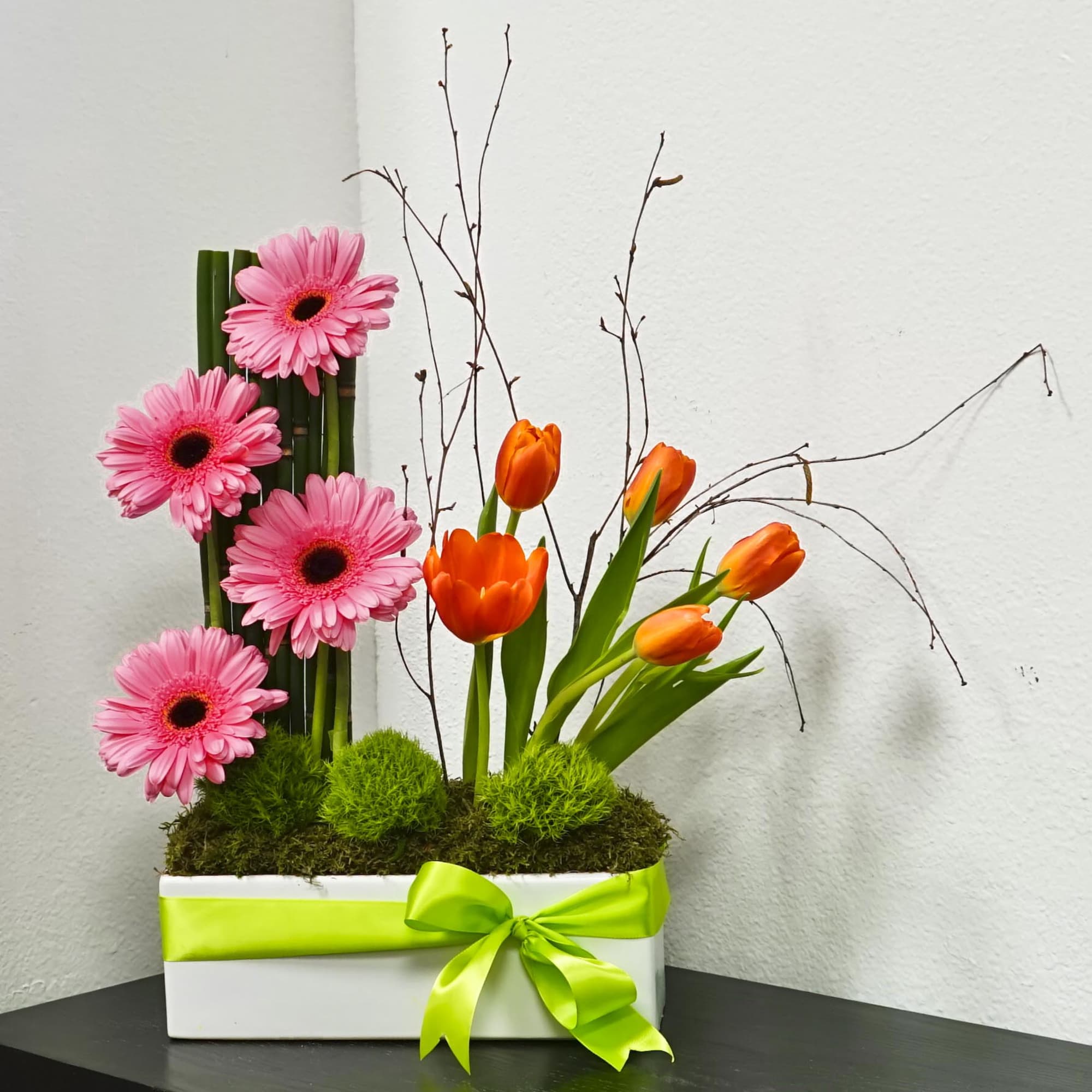 Pink gerbera daisies and orange tulips in a white box with a green ribbon, photo 2 of 4