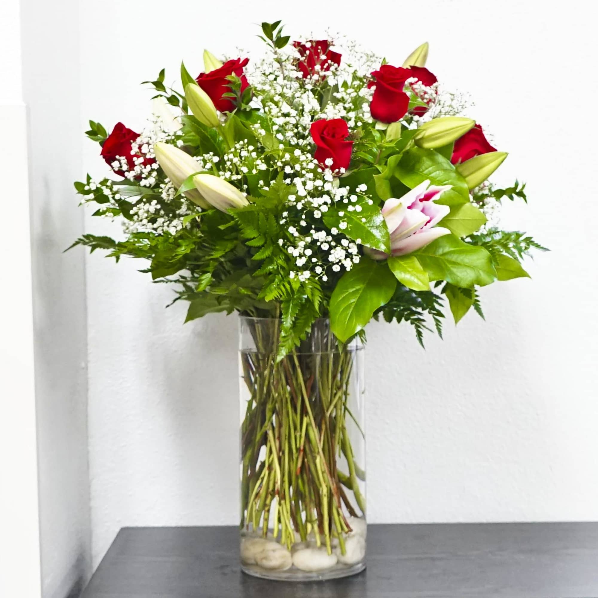 Red roses and white lilies in a clear glass vase, photo 2 of 3