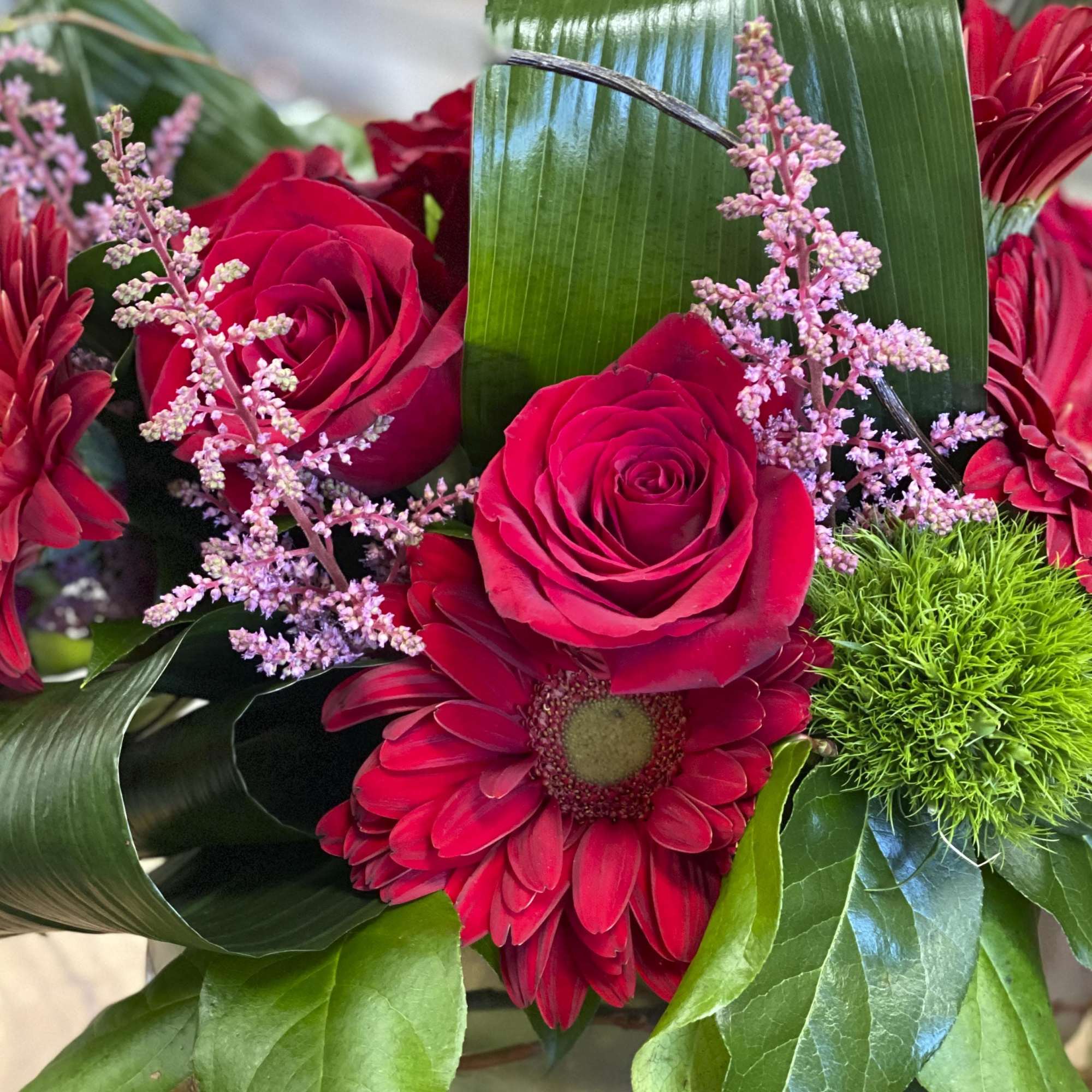 Bouquet of red roses and gerbera daisies with pink filler flowers