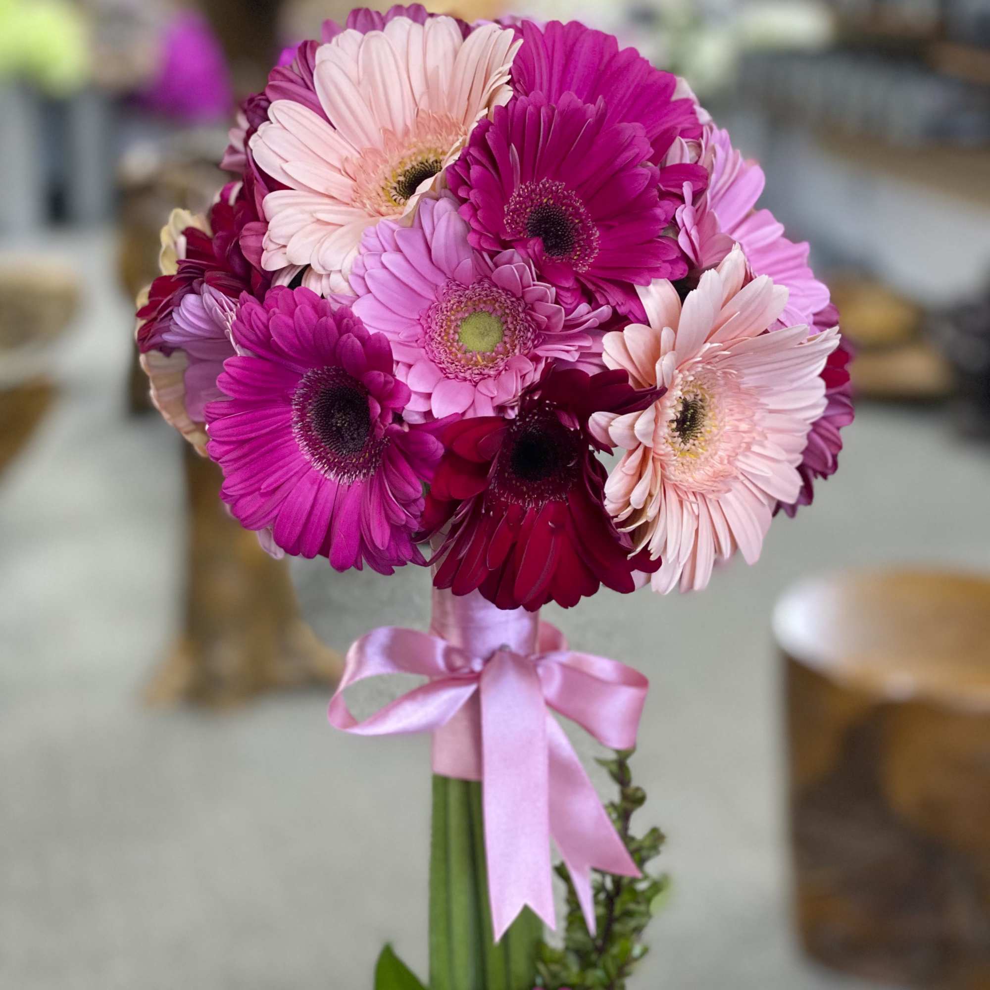 Bouquet of pink and magenta gerbera daisies tied with a pink ribbon