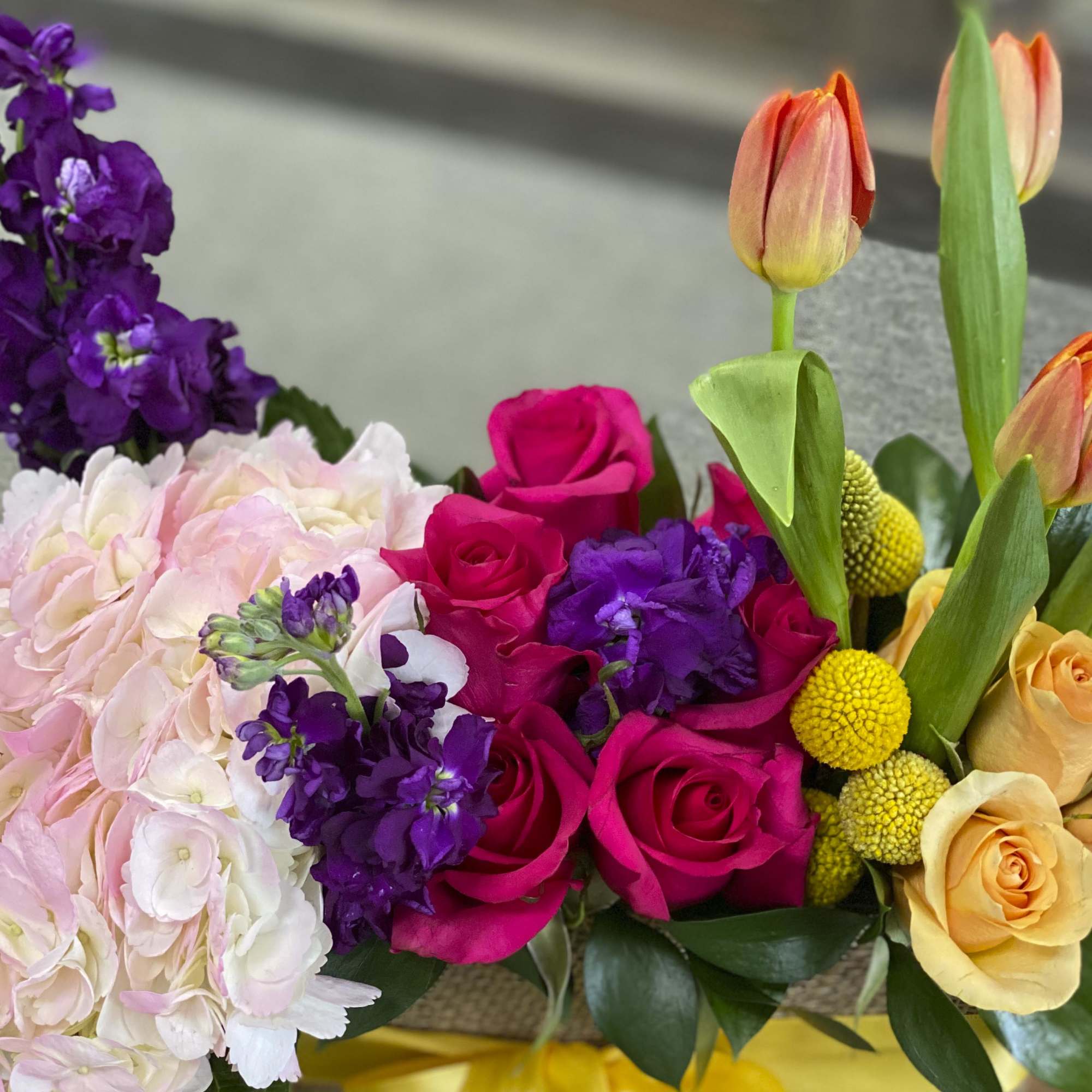 Bouquet of pink and yellow roses with tulips and purple flowers