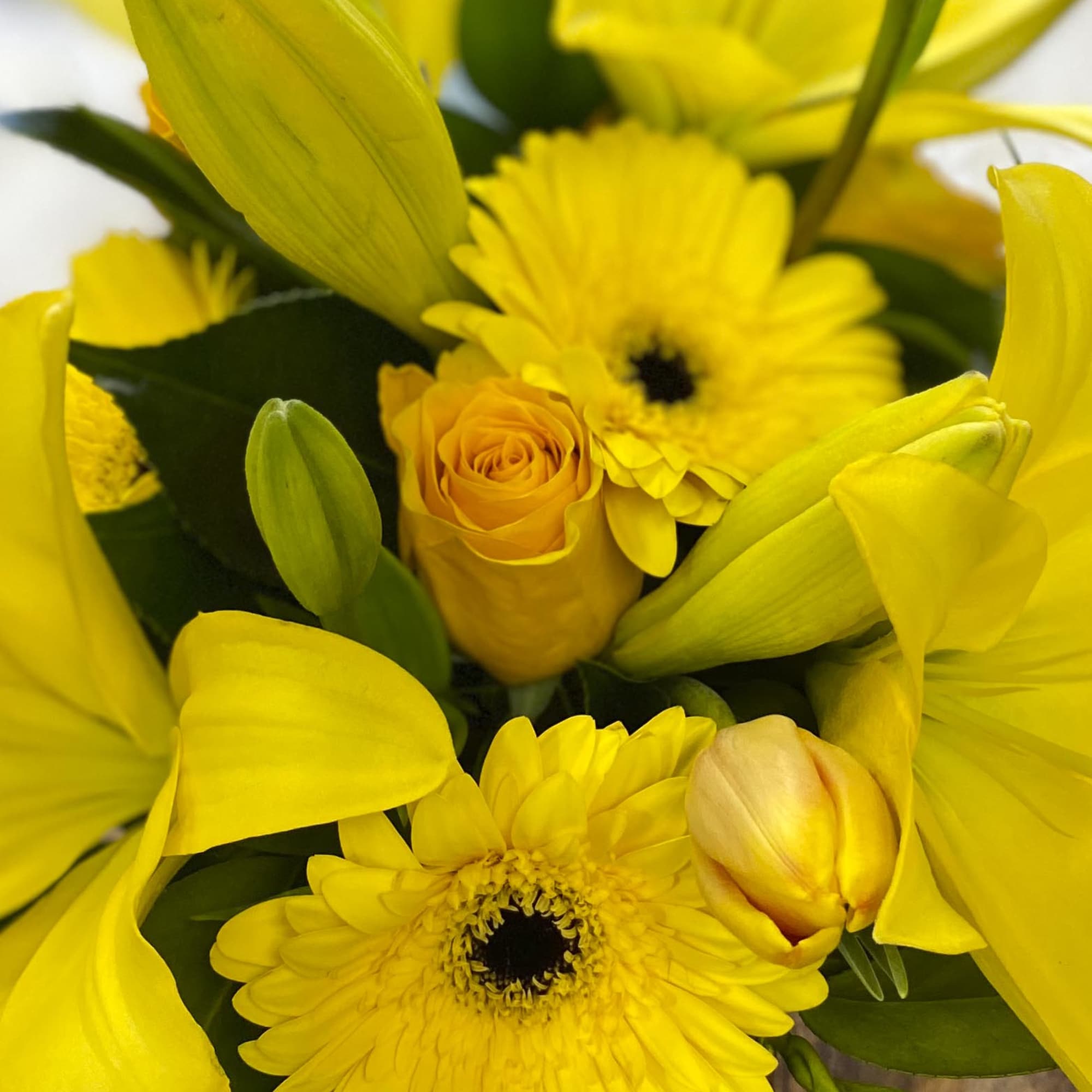 Yellow bouquet with lilies, gerbera daisies, and a rose