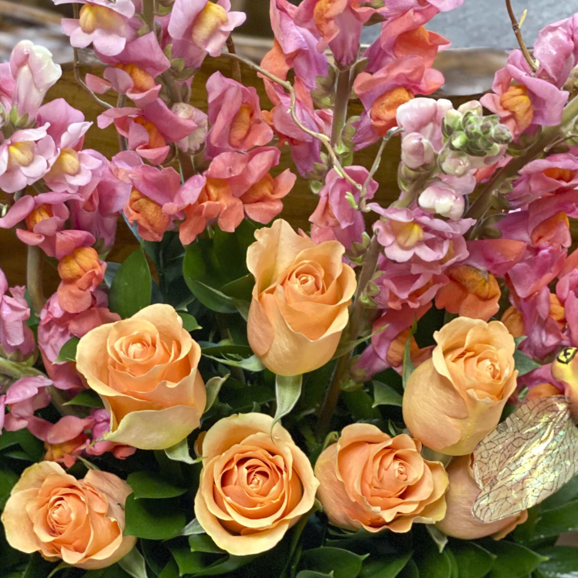 Orange roses with pink snapdragons in a mixed bouquet