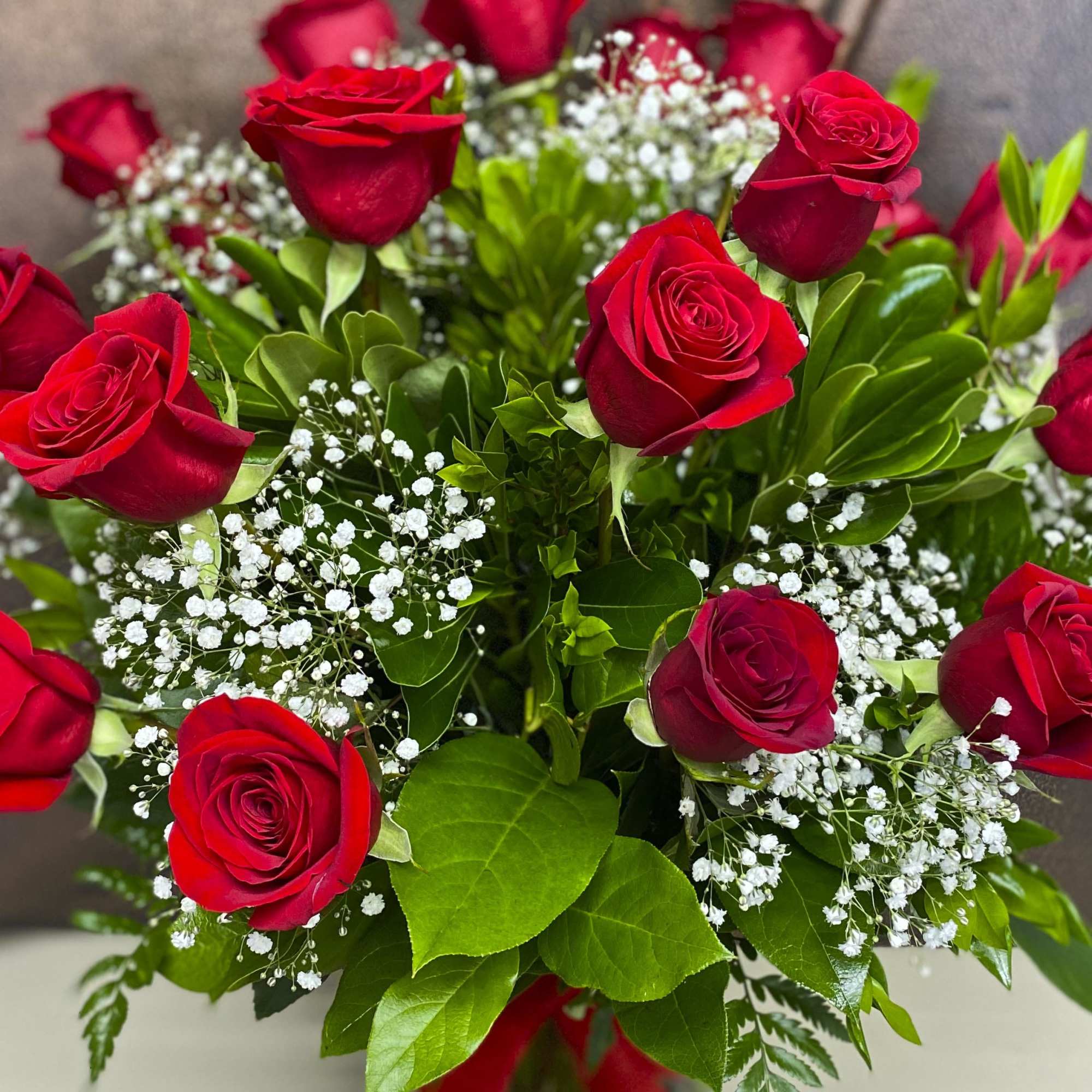 Bouquet of red roses with white baby's breath and green foliage