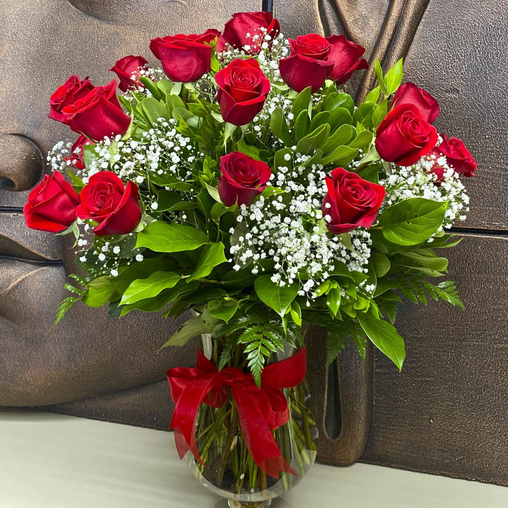 Bouquet of red roses with baby's breath in a glass vase