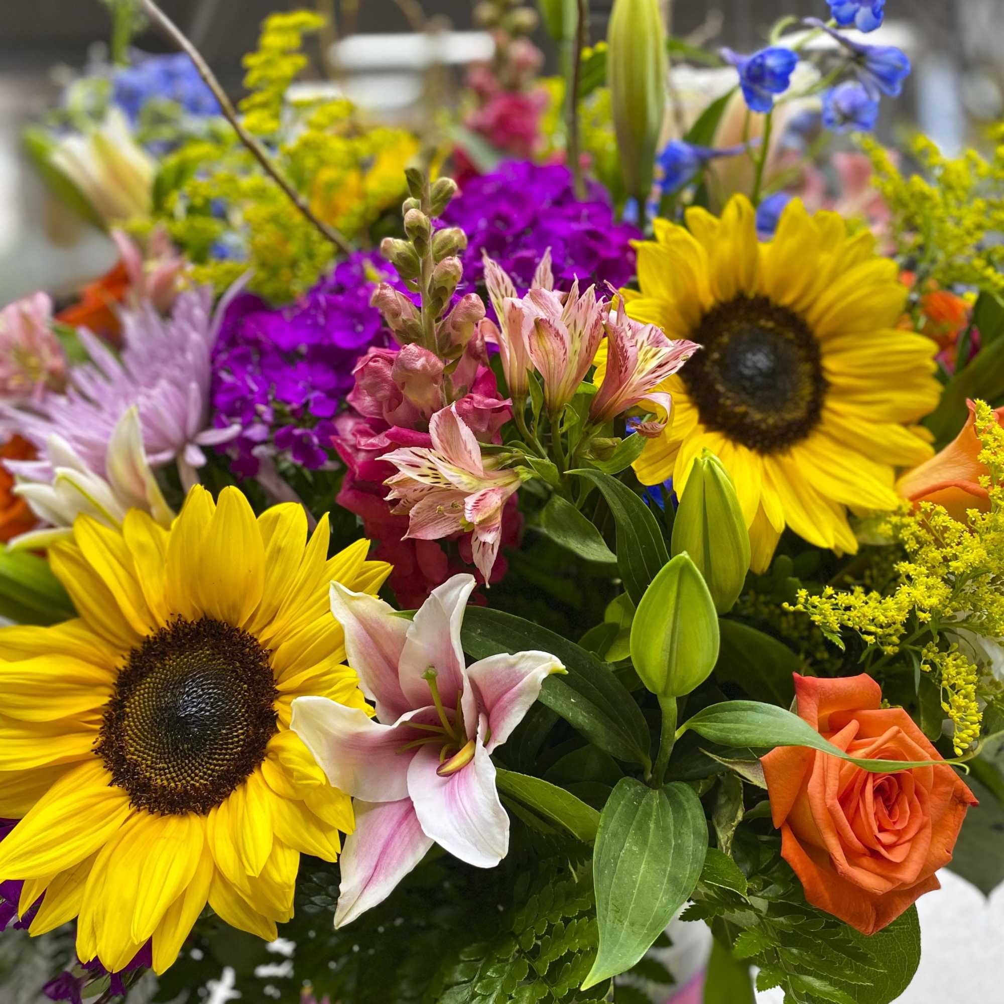Mixed bouquet with sunflowers, lilies, roses, and purple blooms