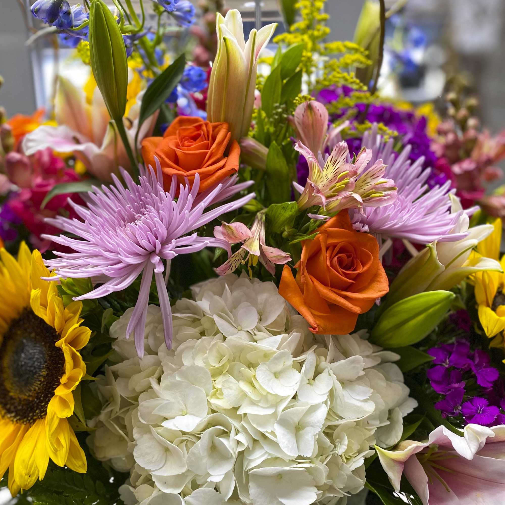 Mixed bouquet with orange roses, white hydrangea, lilies, and purple flowers