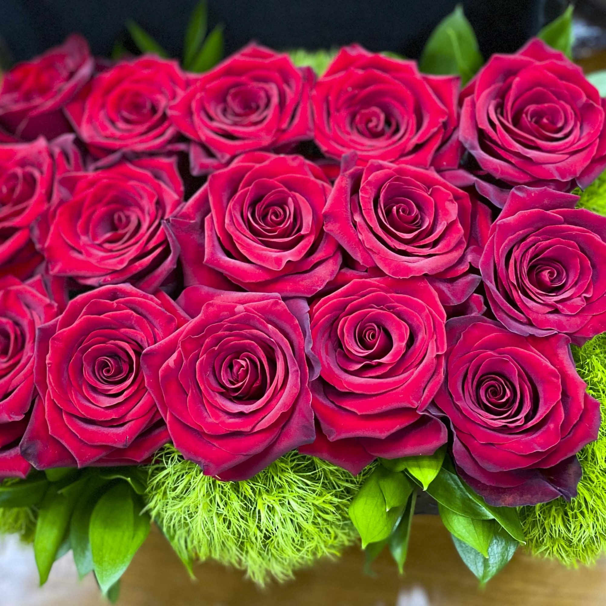 Close-up bouquet of deep pink roses with green filler