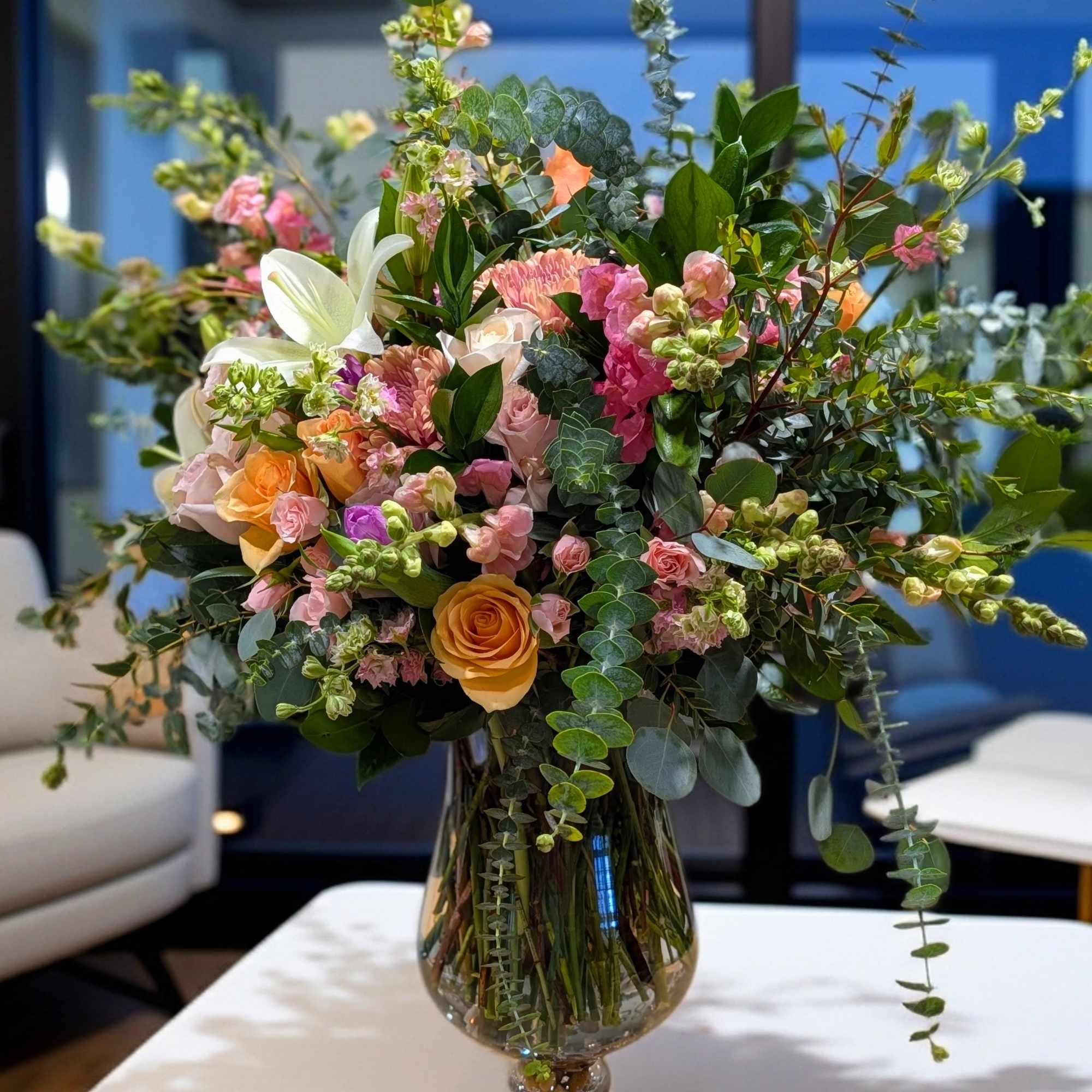 Mixed pink and peach flowers in a clear glass vase