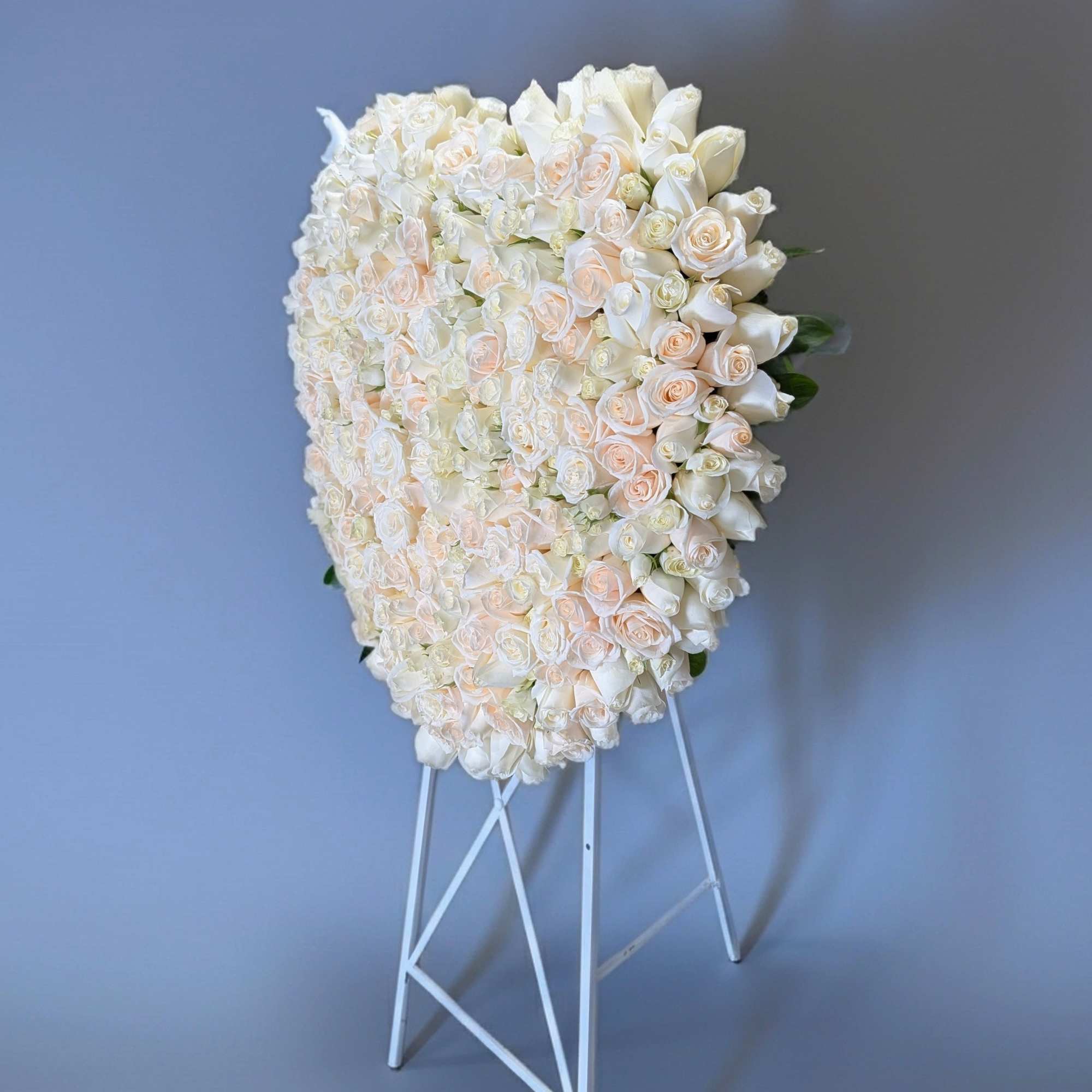 Large white and blush rose arrangement on a white stand