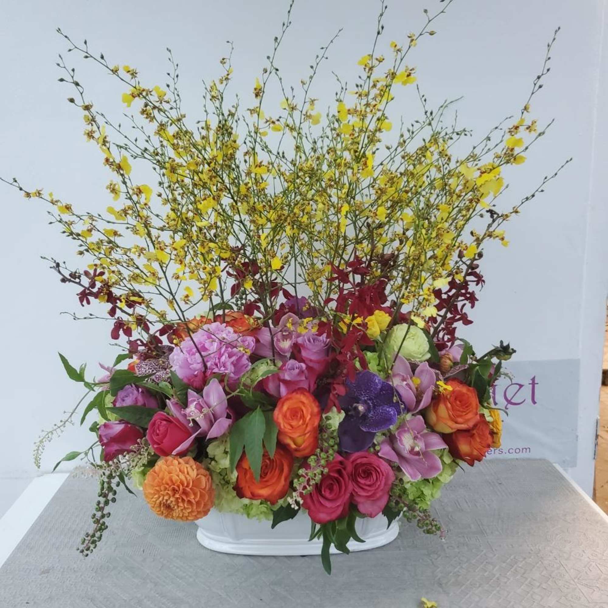 Colorful mixed flower arrangement in a white container