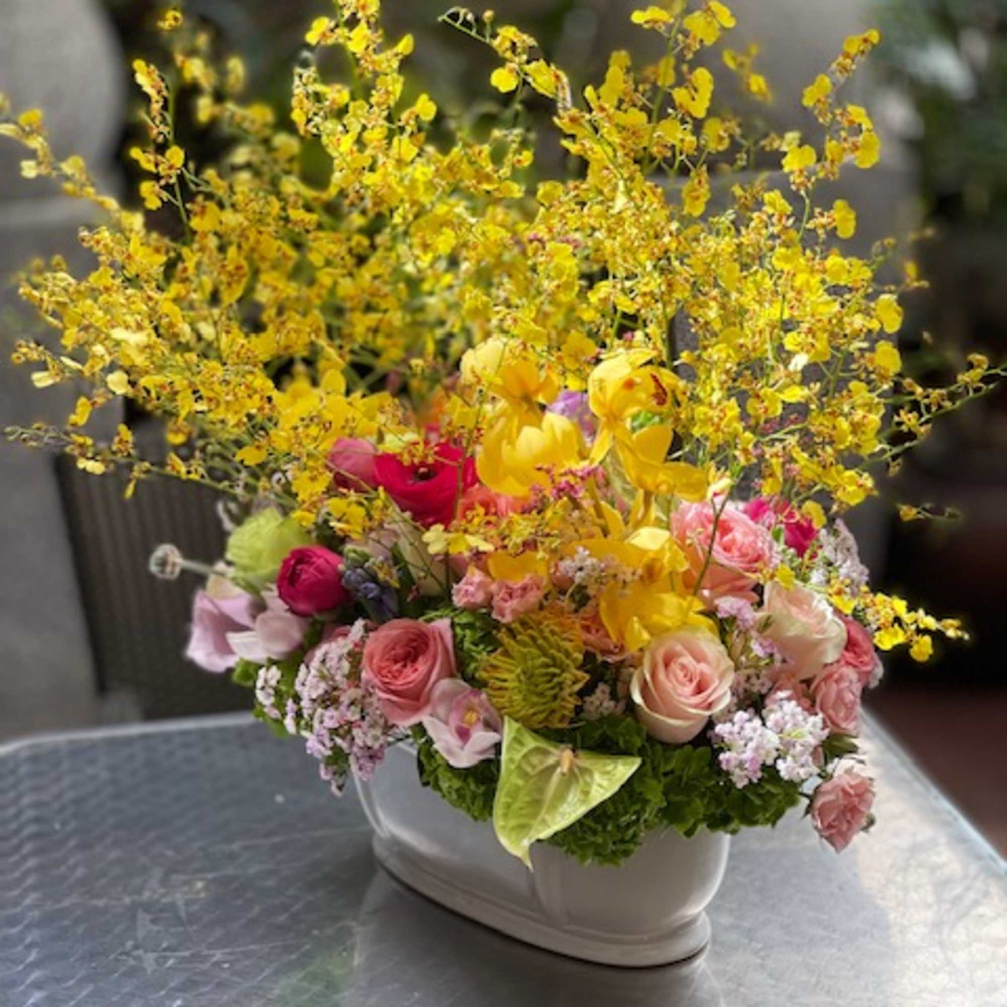 Colorful floral arrangement in a white ceramic container