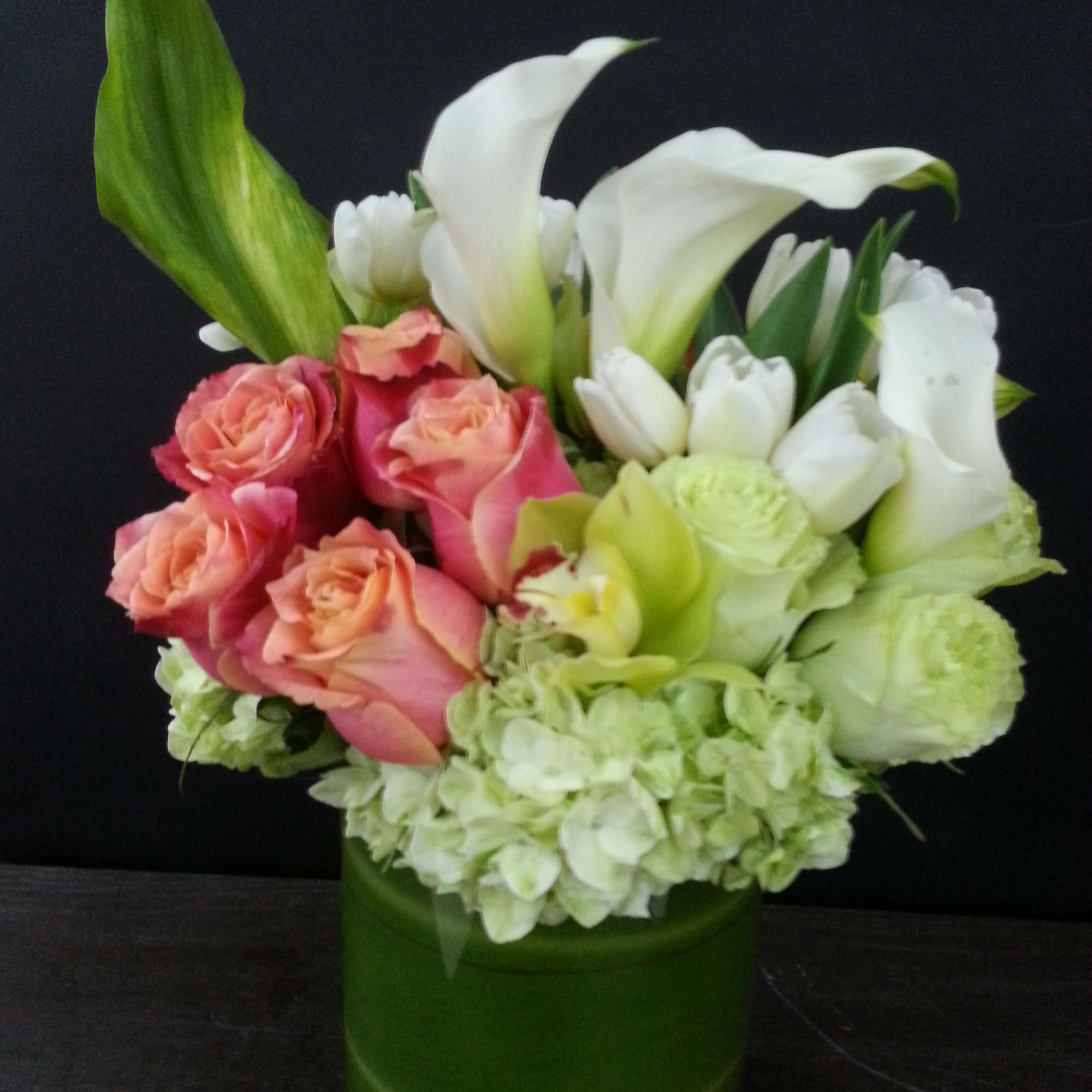 Pink roses and white calla lilies in a green vase