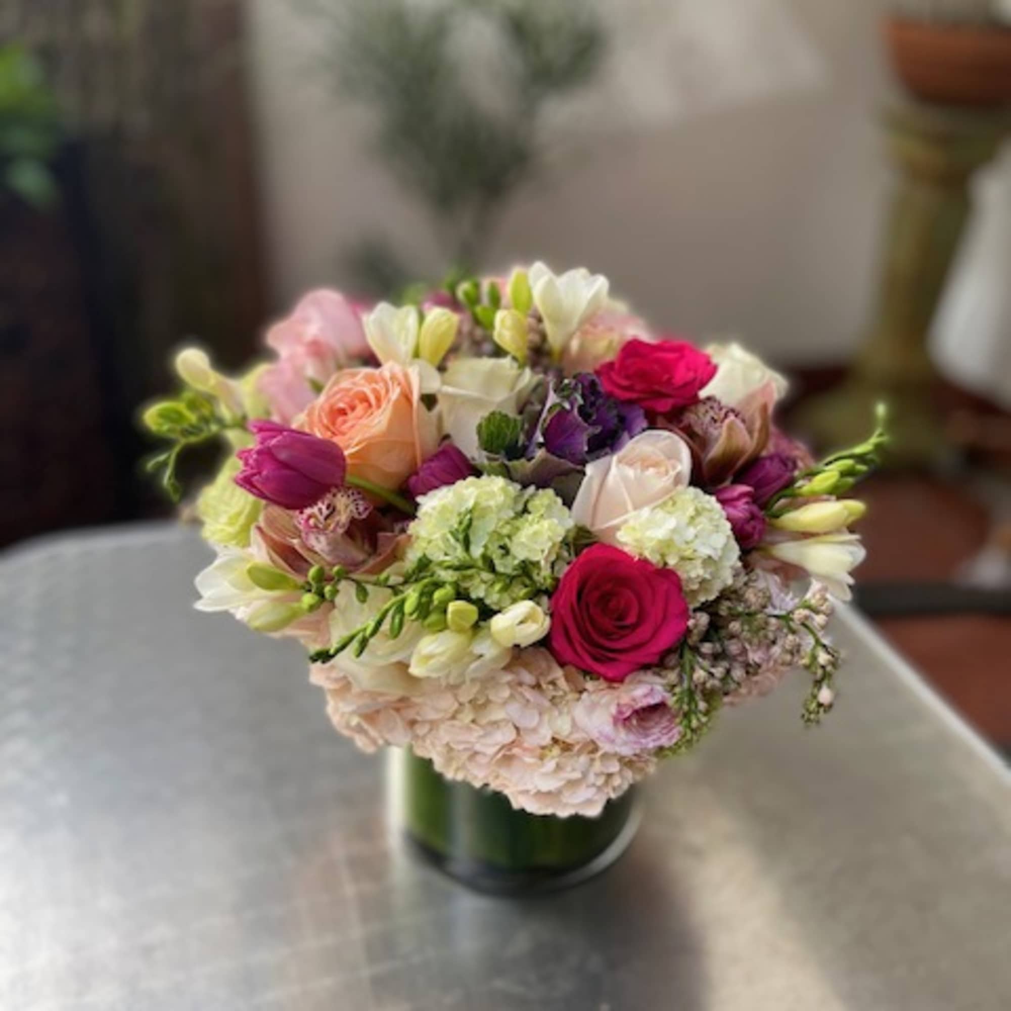 Mixed bouquet of pink, white, and purple flowers in a glass vase