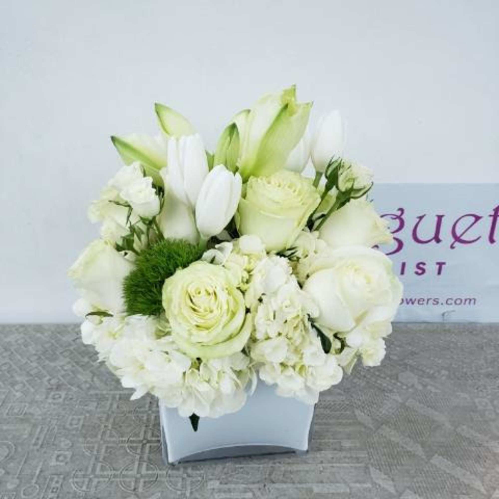 White floral arrangement in a square white vase