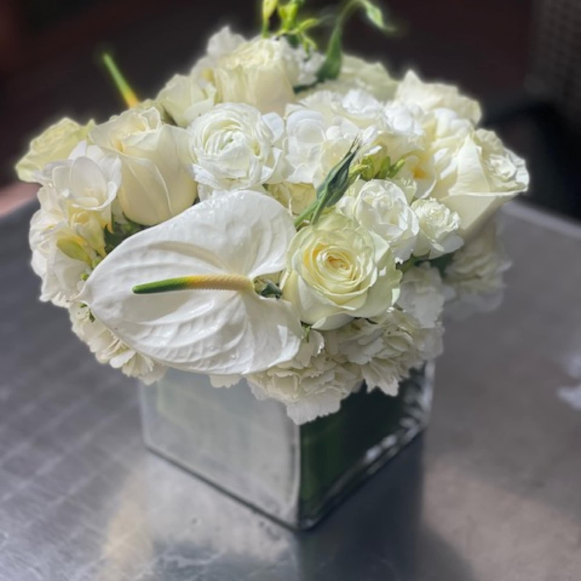 White floral arrangement in a square glass vase