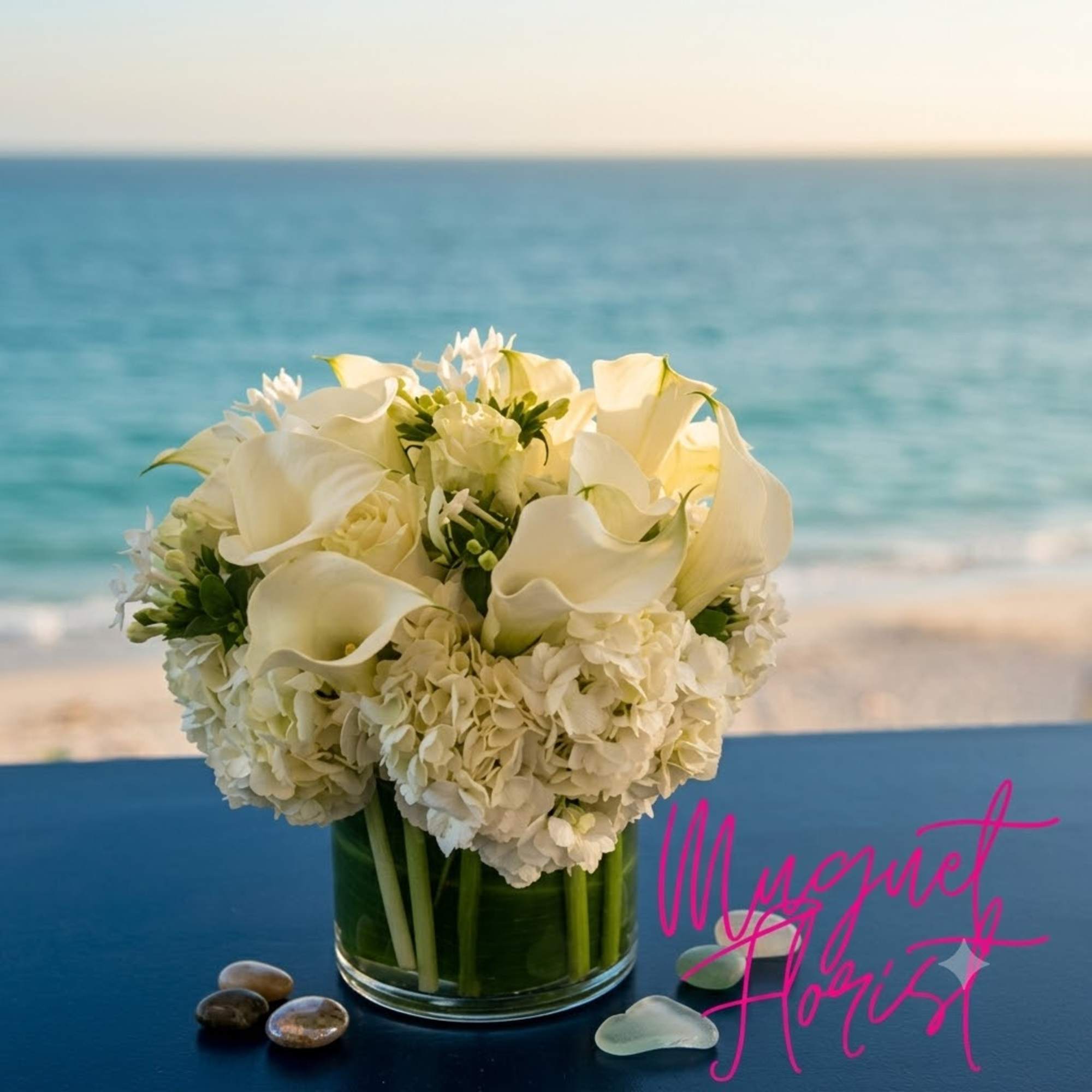 White calla lilies and hydrangeas arranged in a clear glass vase