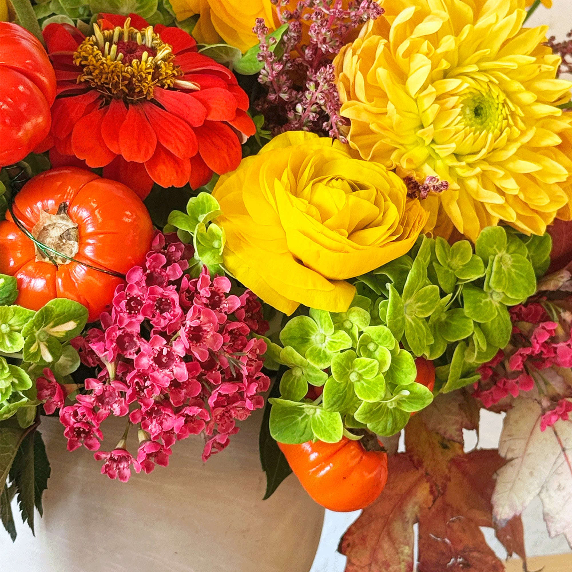 Bright bouquet with yellow and red flowers and small orange pumpkins
