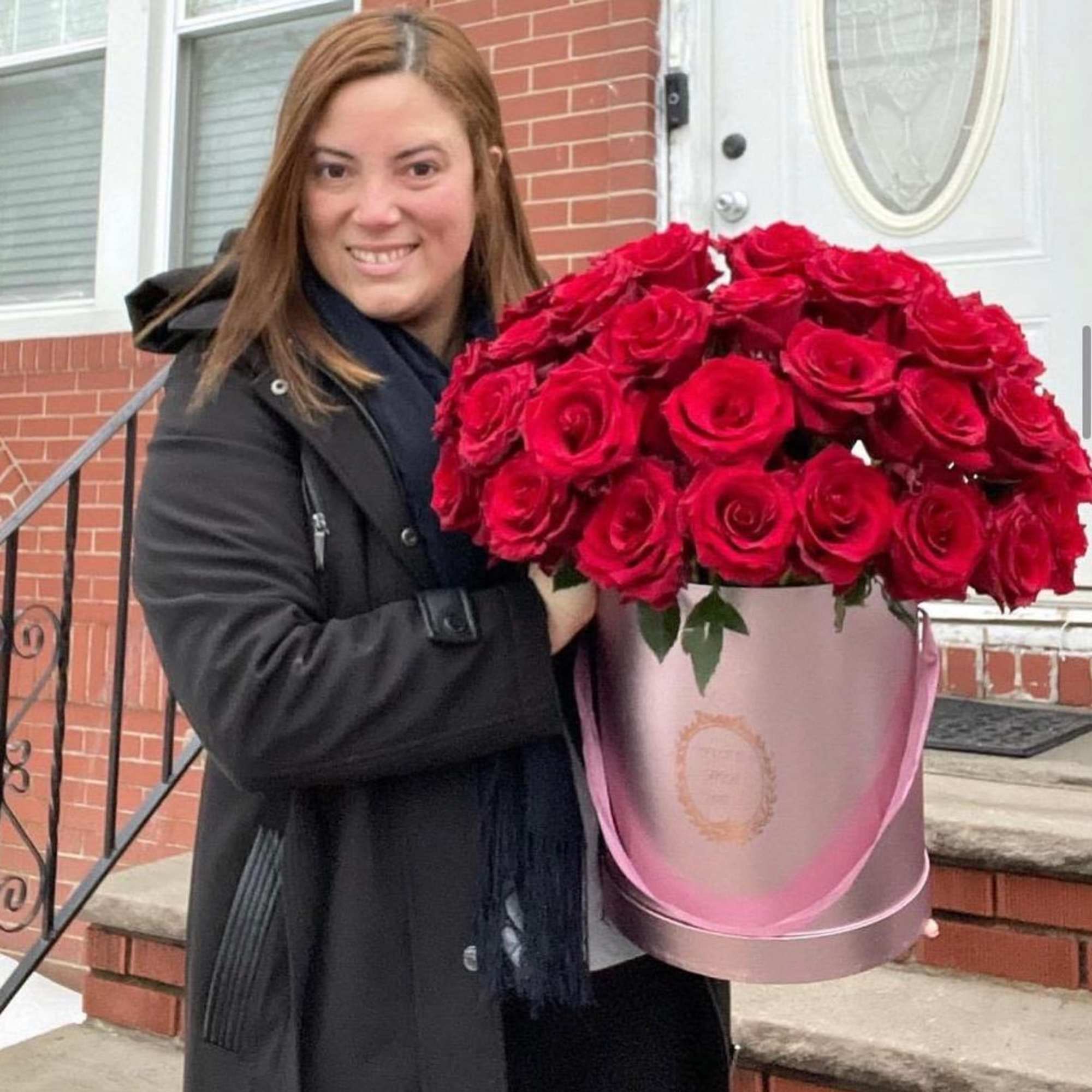 Woman holding a large box of red roses