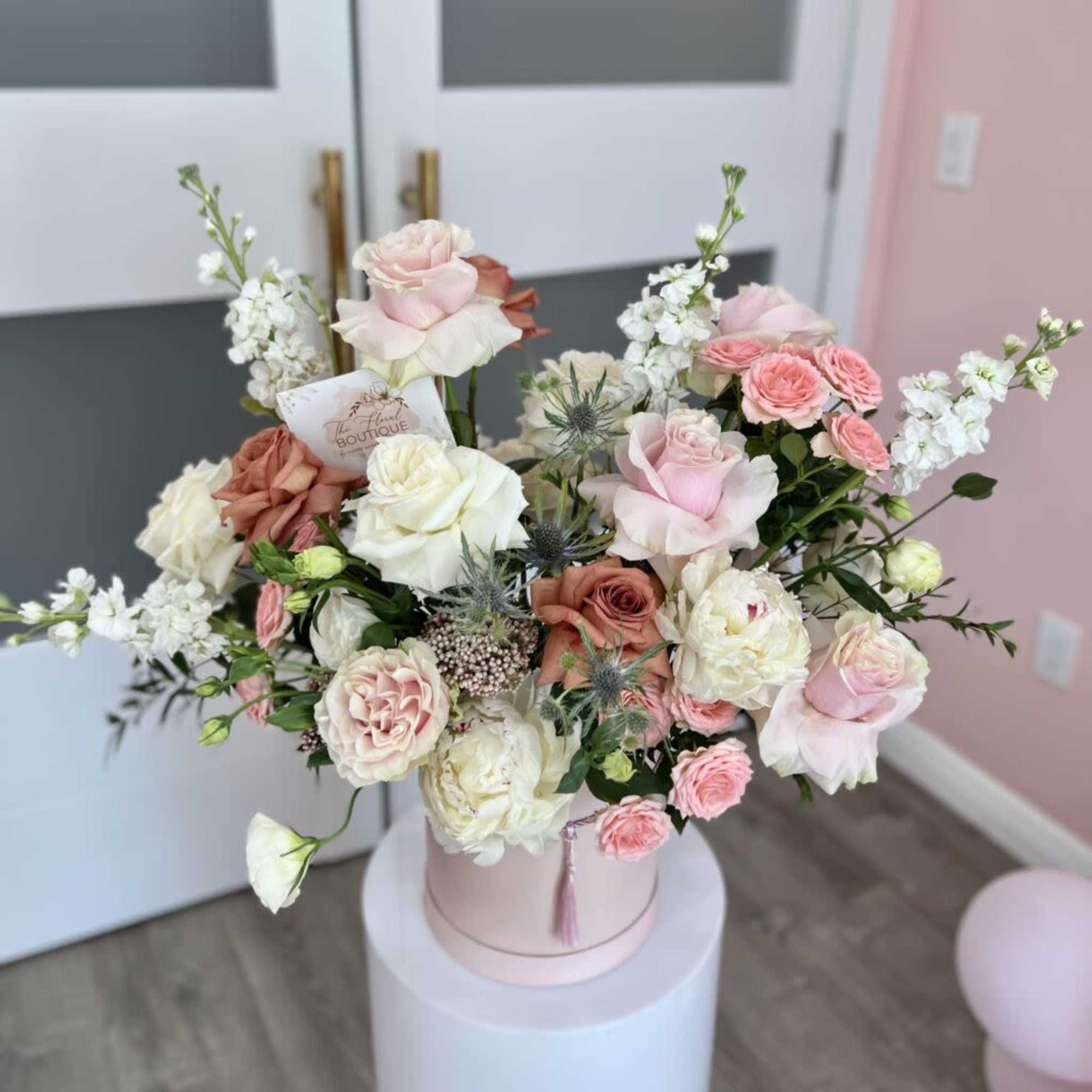 Pink and white rose bouquet in a round hat box