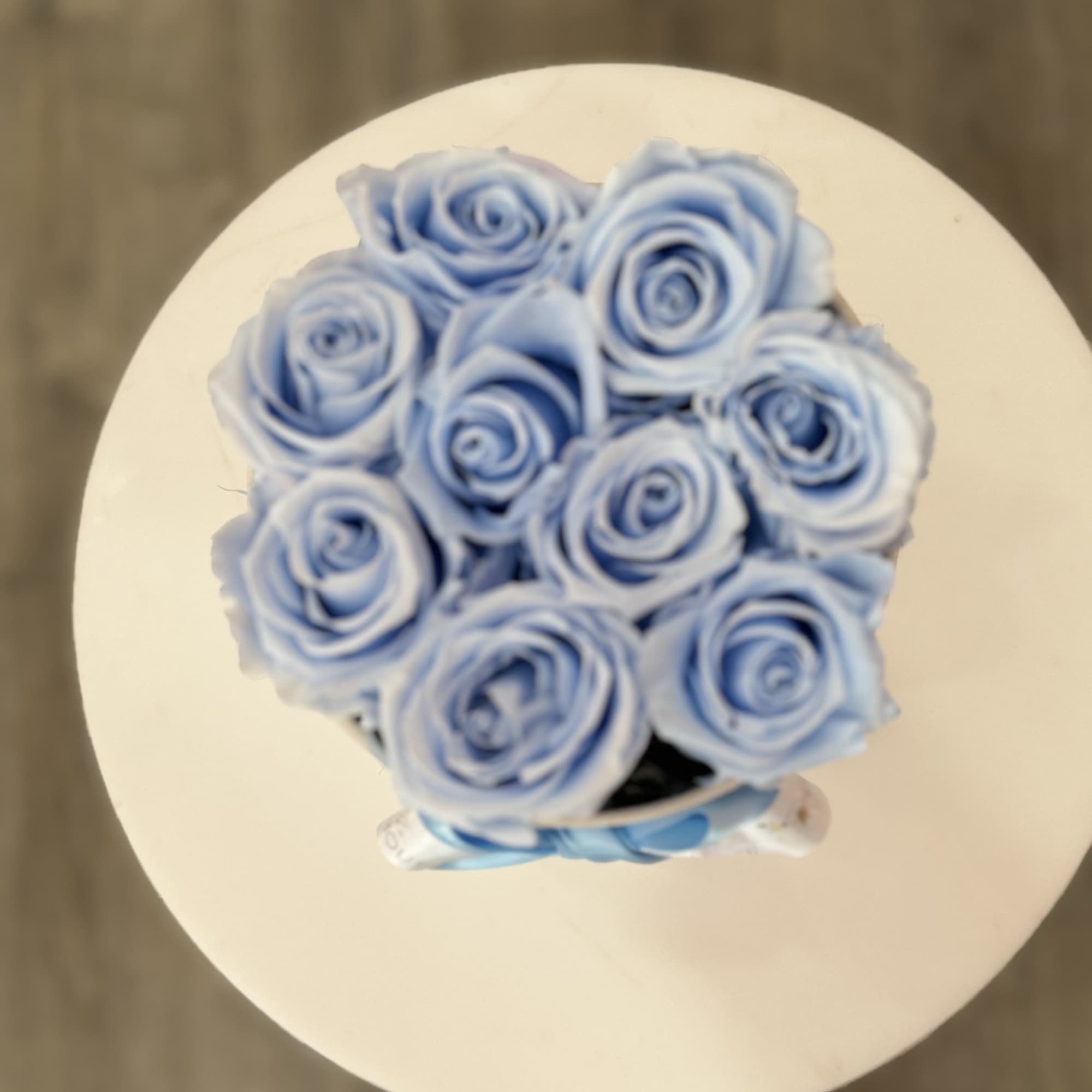 Bouquet of light blue roses on a round white surface