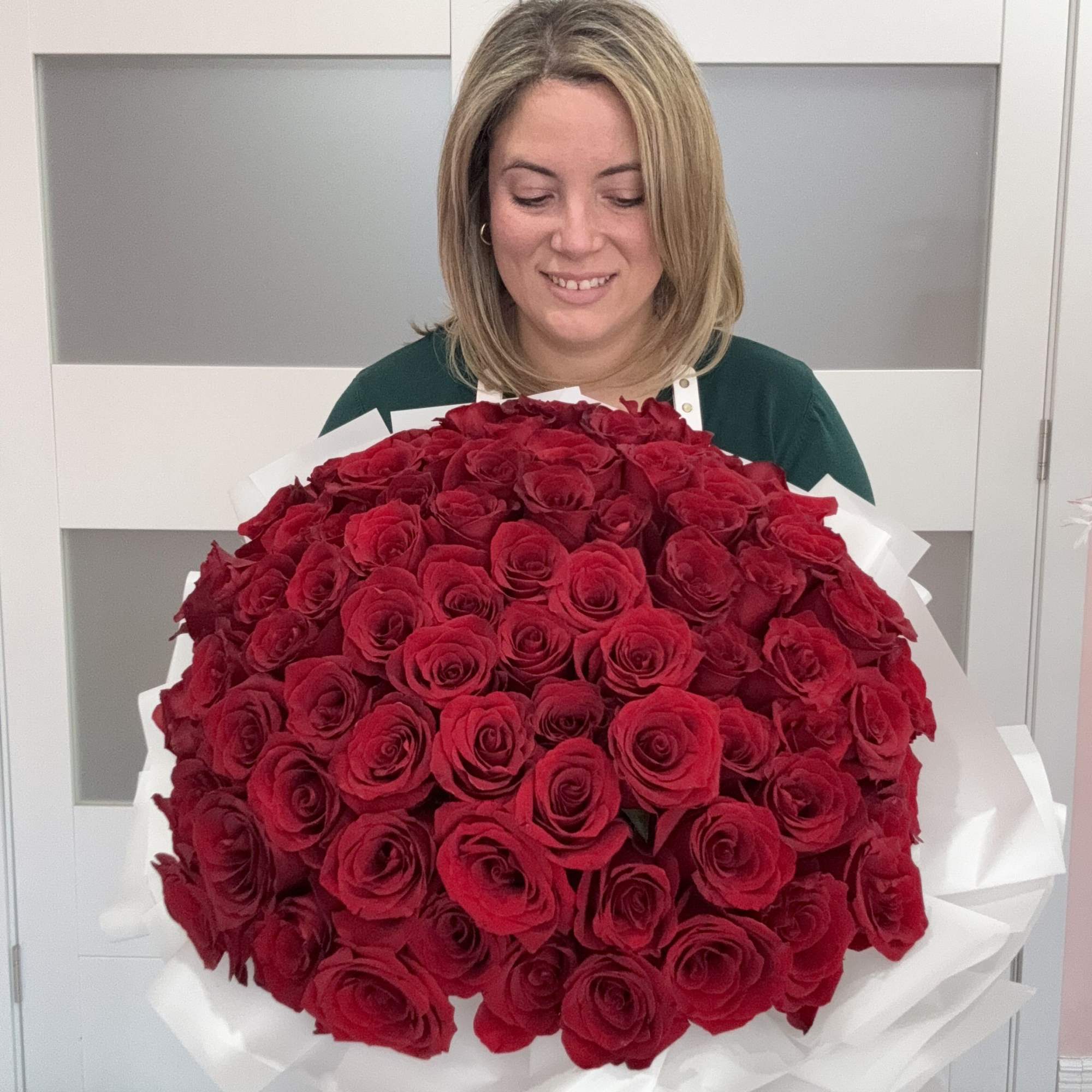 Large bouquet of red roses wrapped in white paper