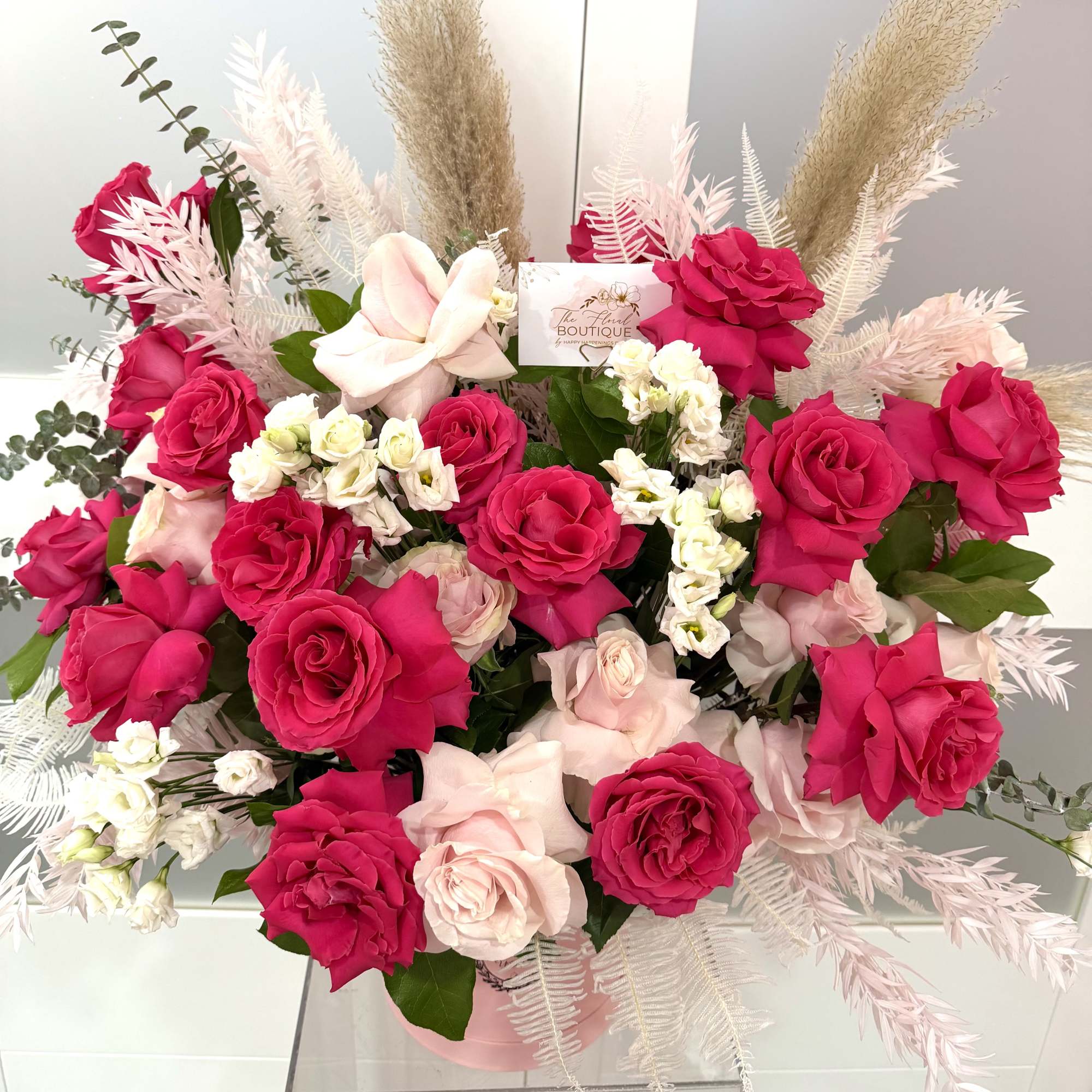 Bouquet of hot pink and blush roses in a pink box