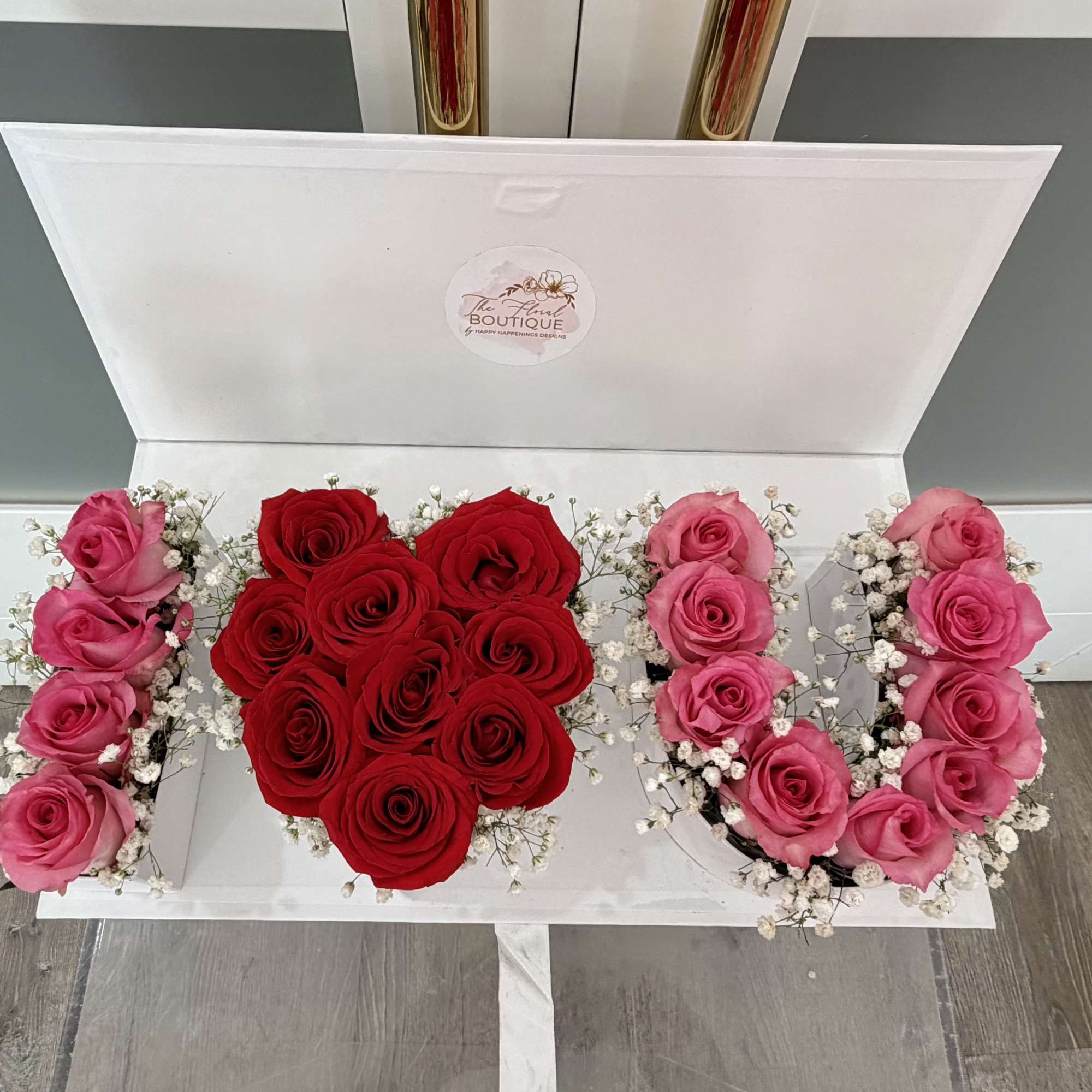 Open white box with red and pink roses arranged inside