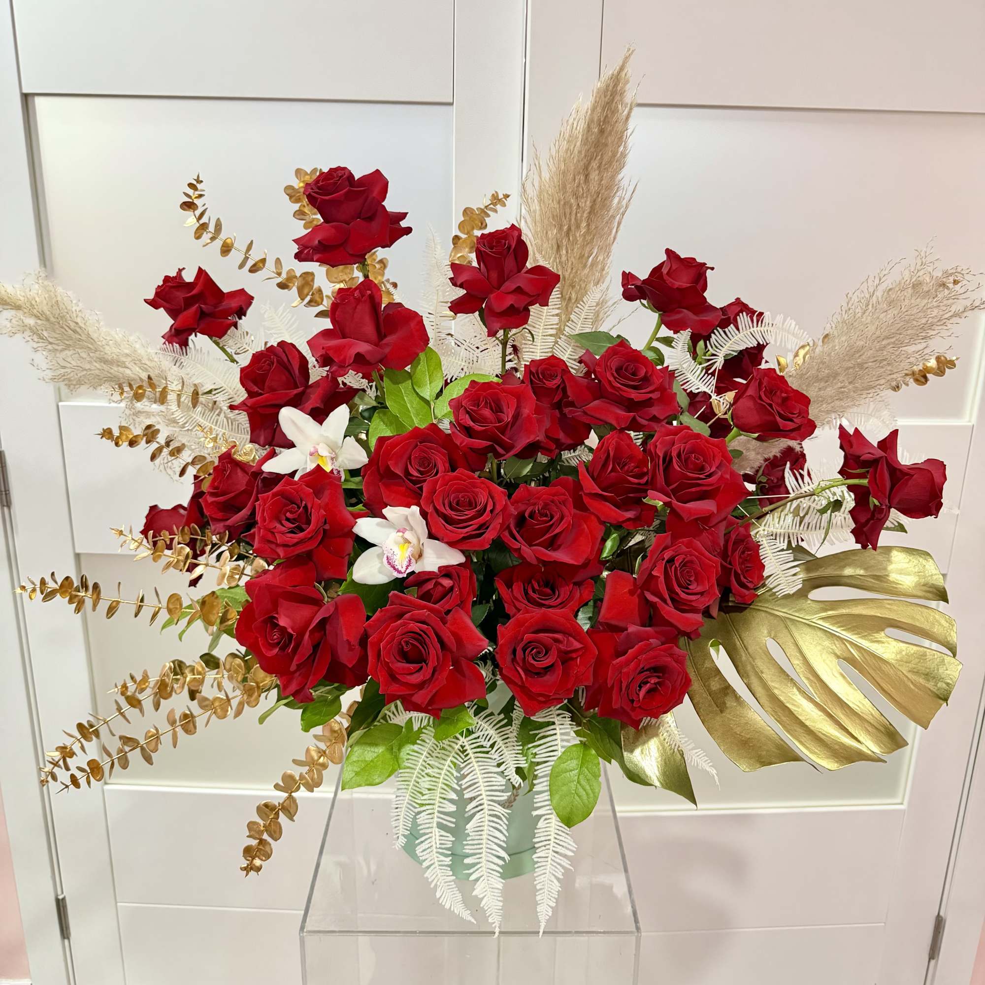 Large bouquet of red roses with white orchids in a vase
