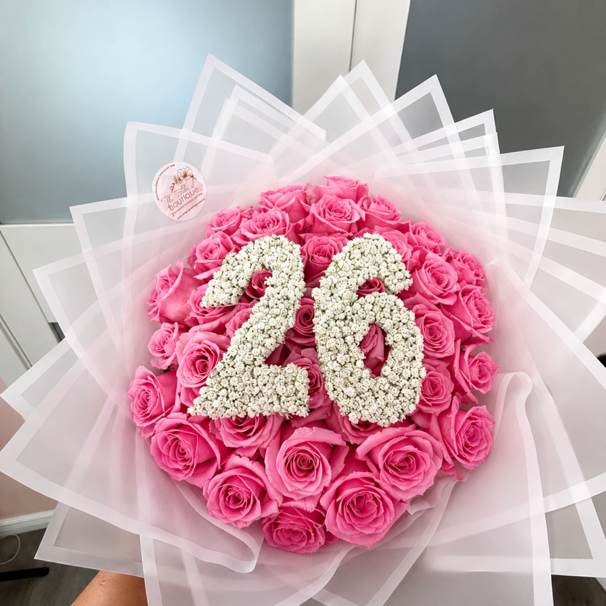 Pink rose bouquet with a white floral number 26 centerpiece